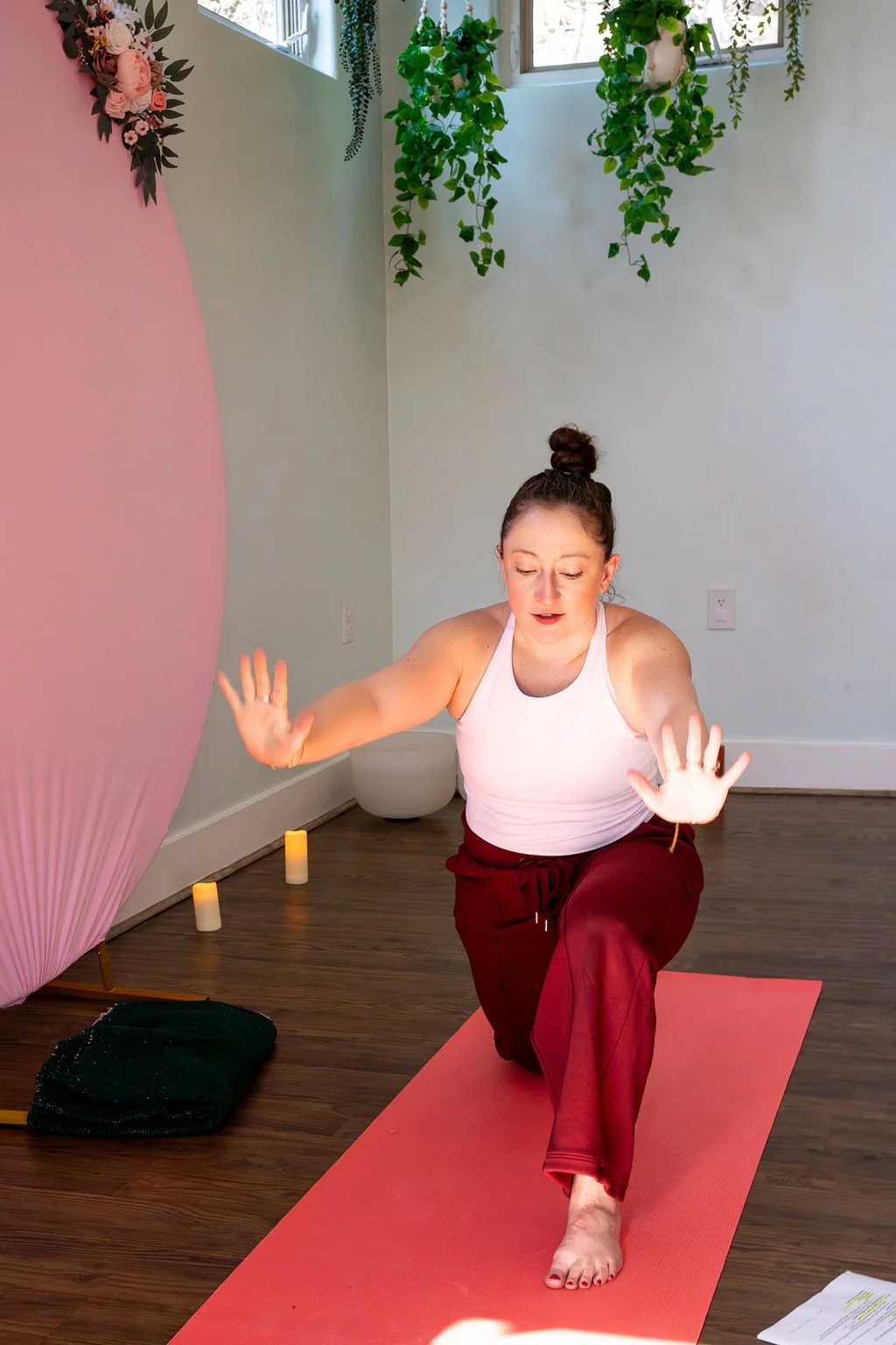 Katie Porras kneeling on a mat with arms extended during a guided movement session