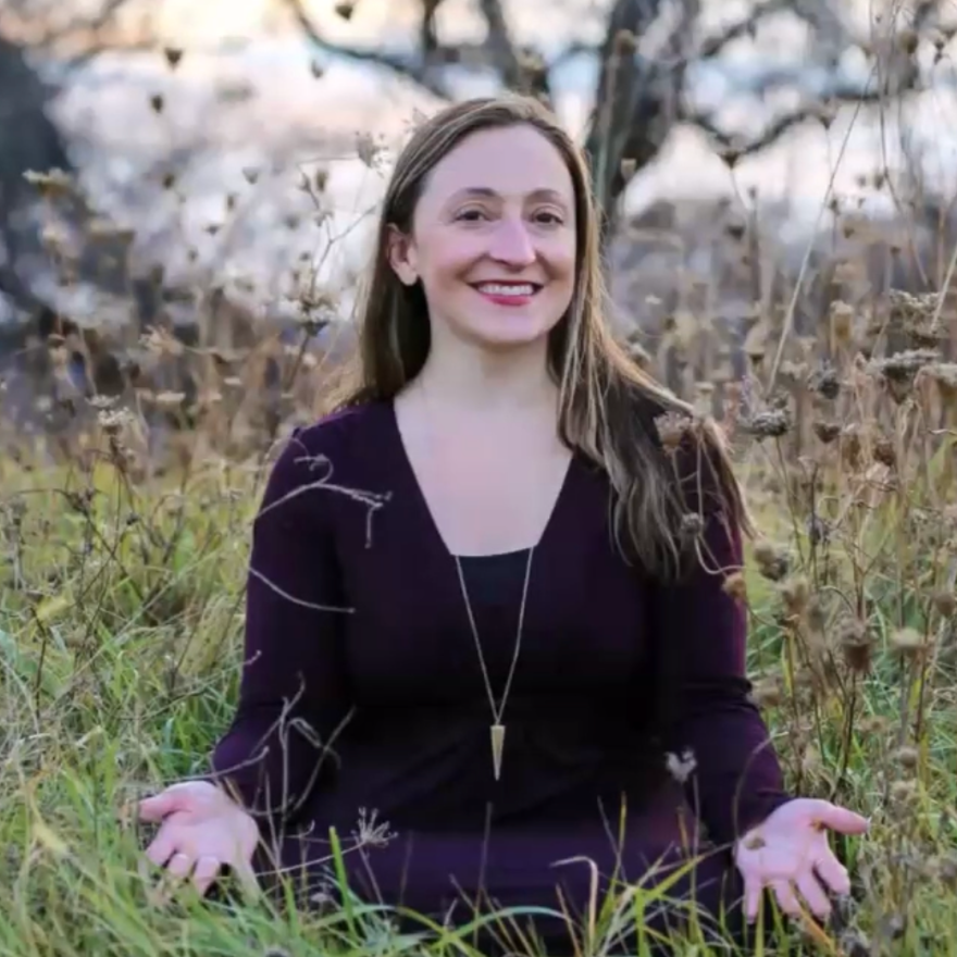 Katie in a purple top in a field of wildflowers