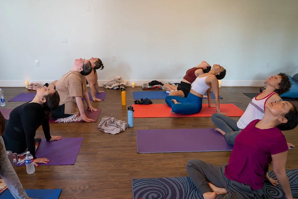 Retreat attendees stretching together on mats in a group class