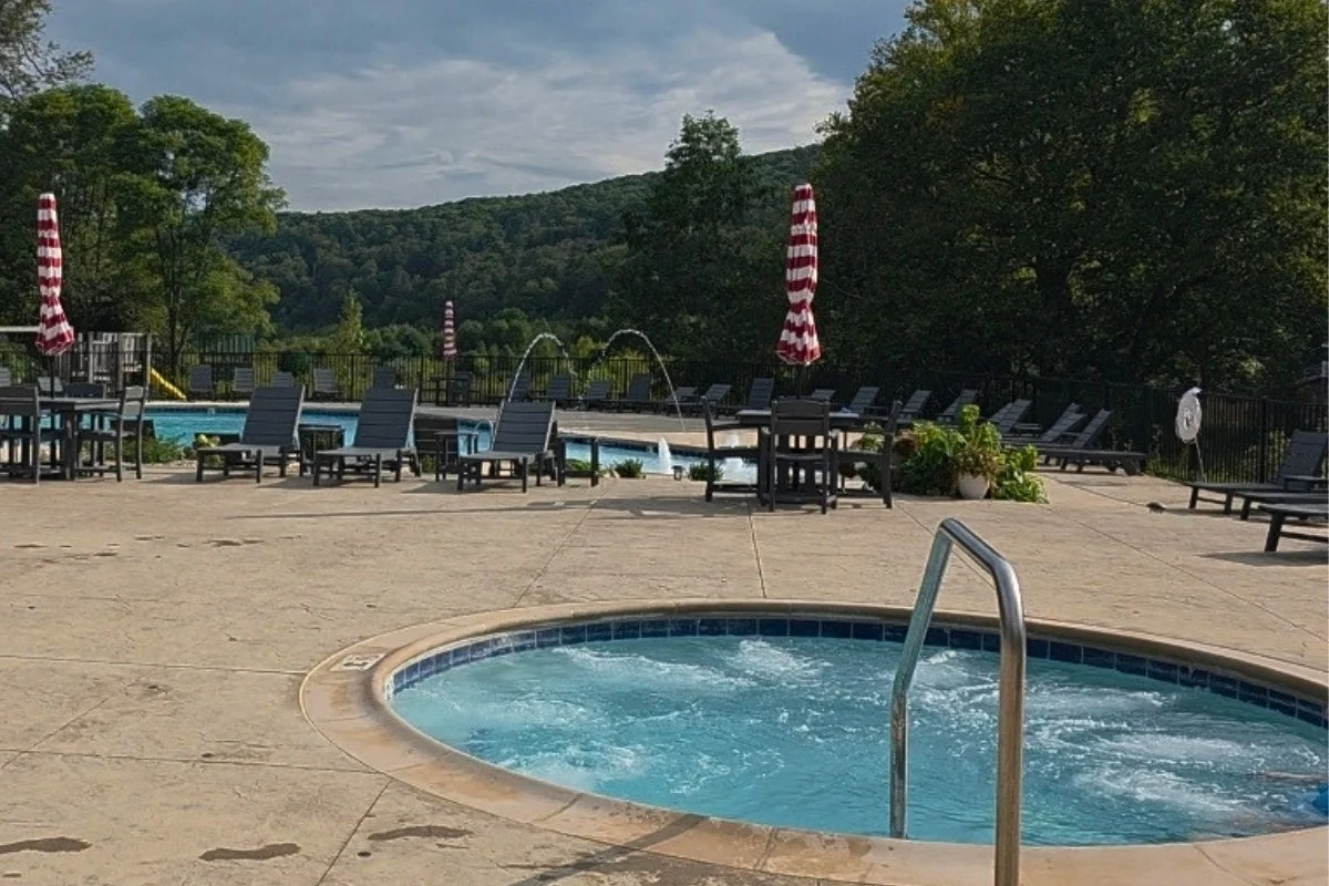 Outdoor pool and hot tub surrounded by mountain scenery at Mountain Lake Lodge
