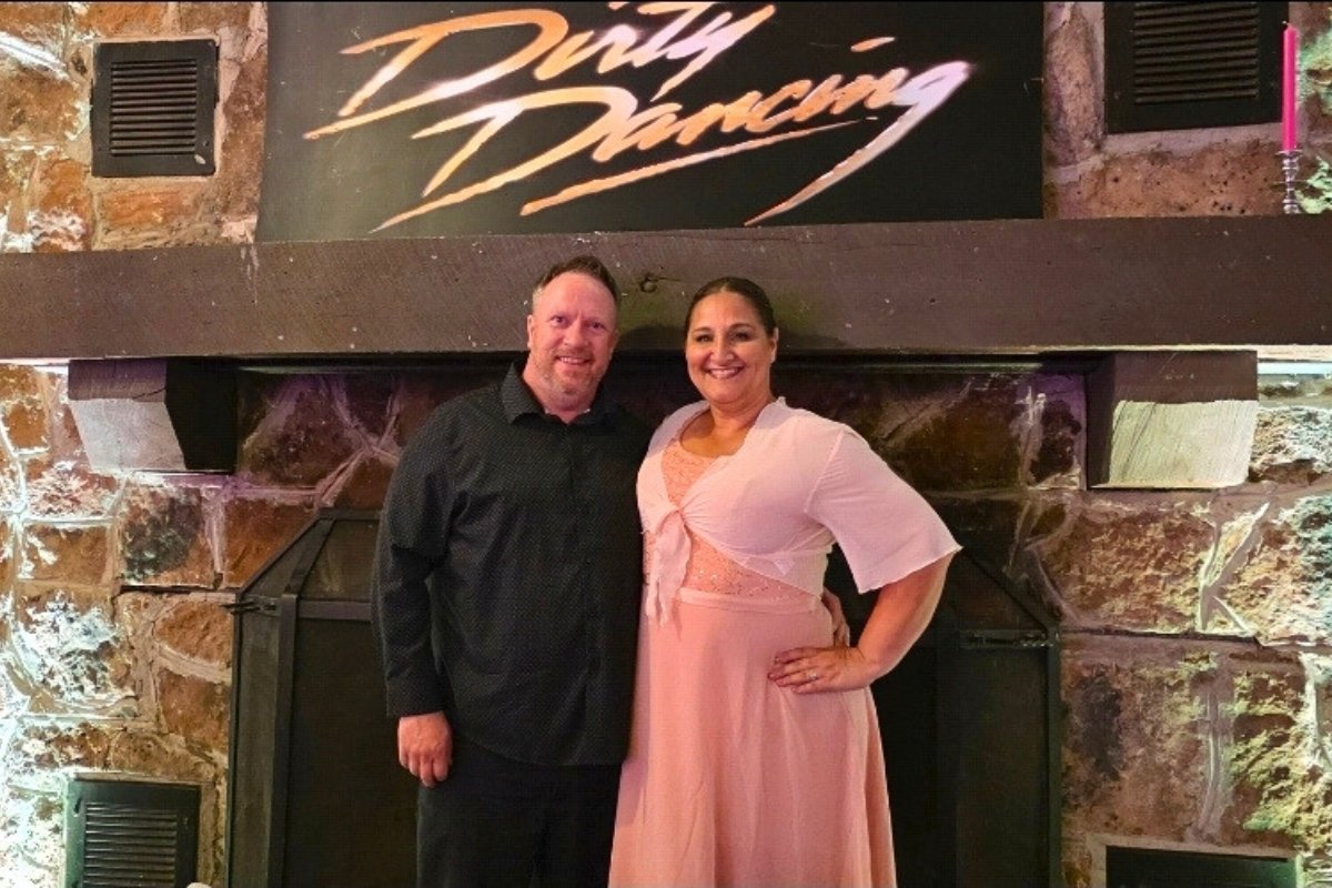 Leigh and Rich in front of the Dirty Dancing sign inside Mary’s Barn at Mountain Lake Lodge
