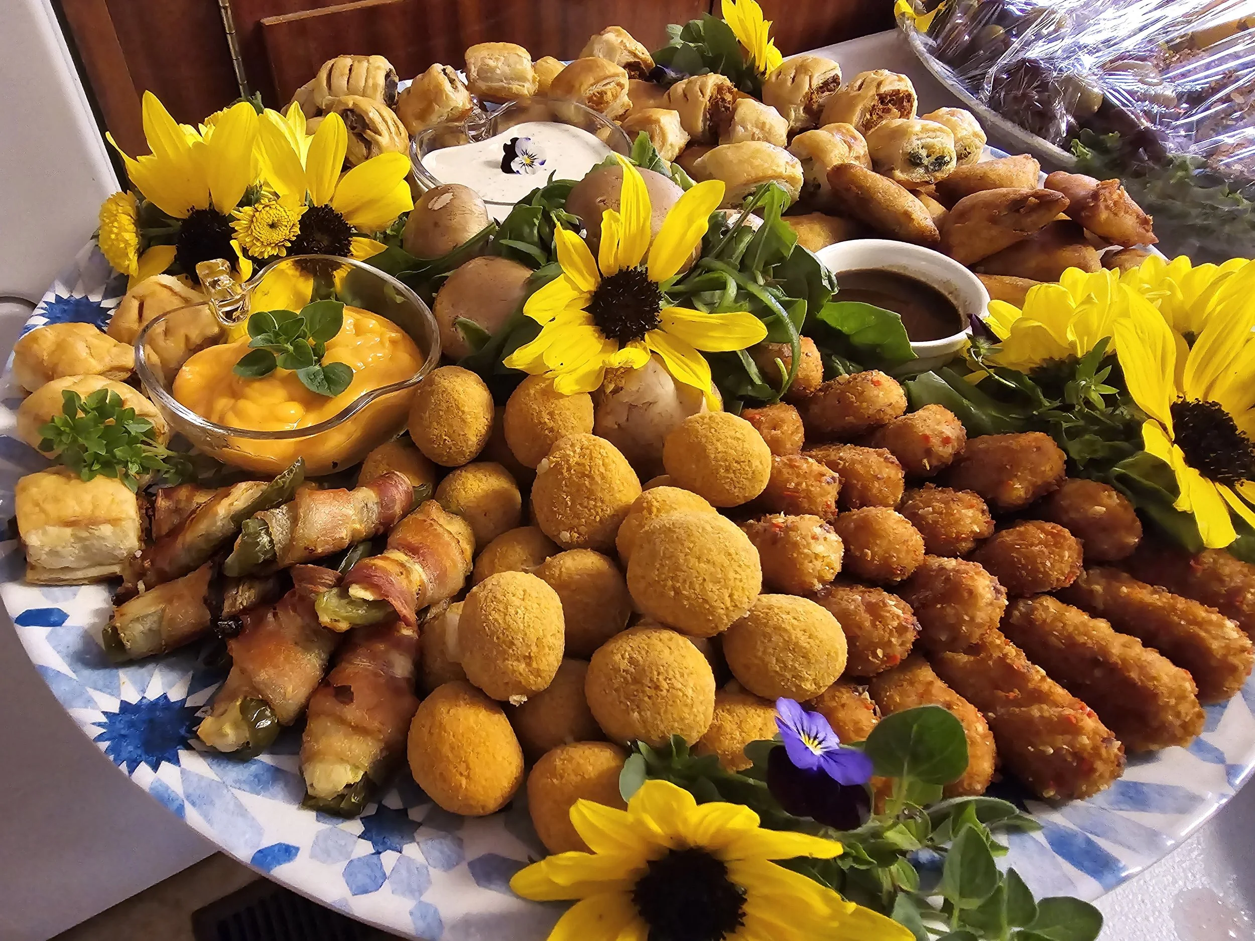Party platter of warm appetizers decorated with sunflowers