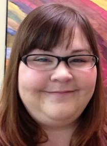 woman with glasses and brown hair smiles