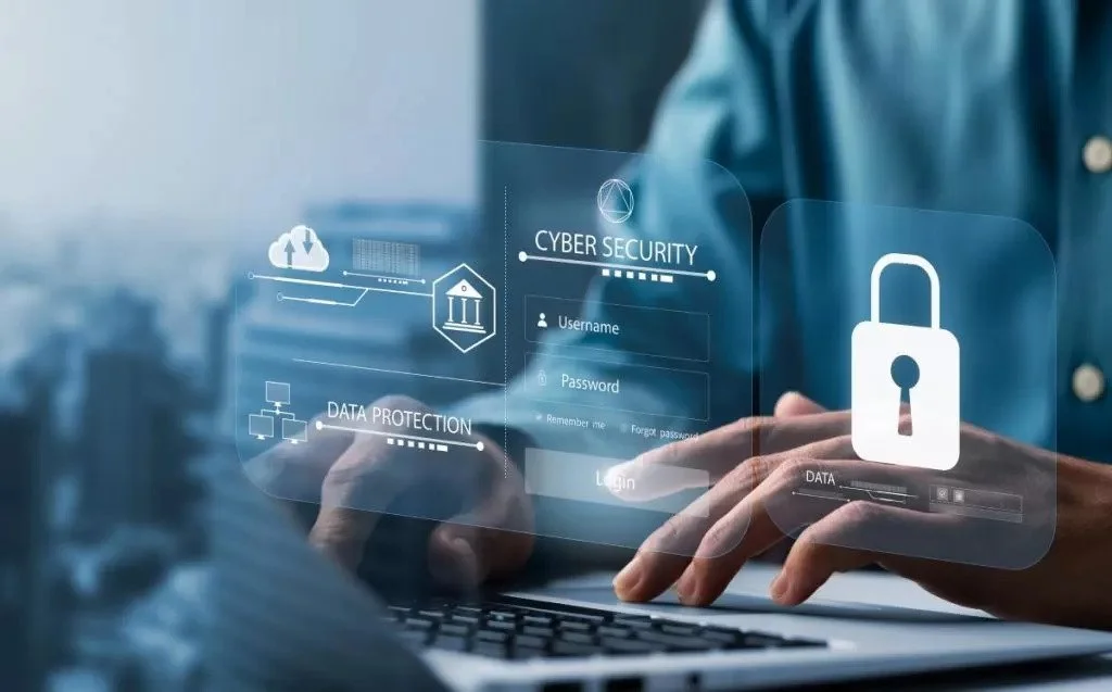 Person typing on laptop with holographic icons of cybersecurity and data protection.