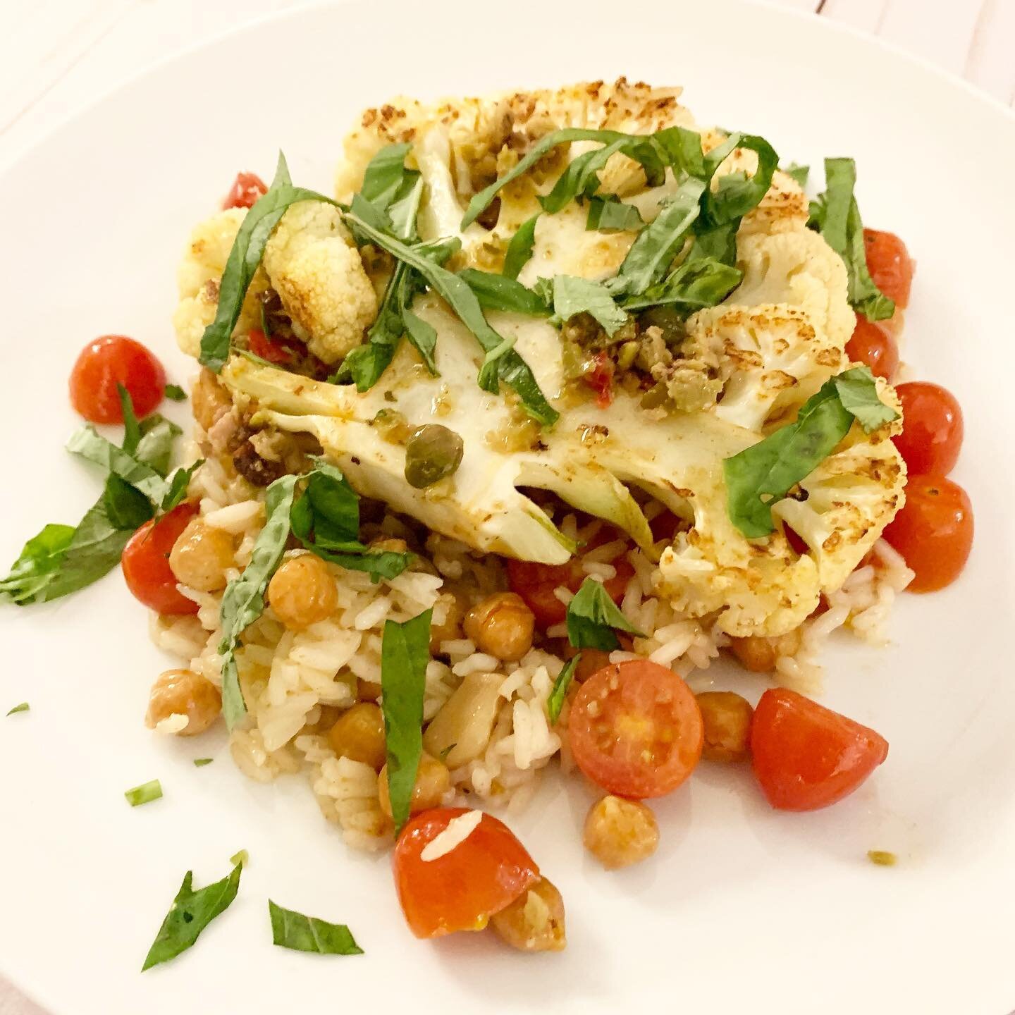loaded cauliflower steak! The tastes of summer are getting closer! This cauliflower steak sits on a bed of basmati rice with olive tapenade, roasted tomatoes, chickpeas, and basil. 😀👌 #eatsbylulu 
- you can find the recipe under the &ldquo;recipe t