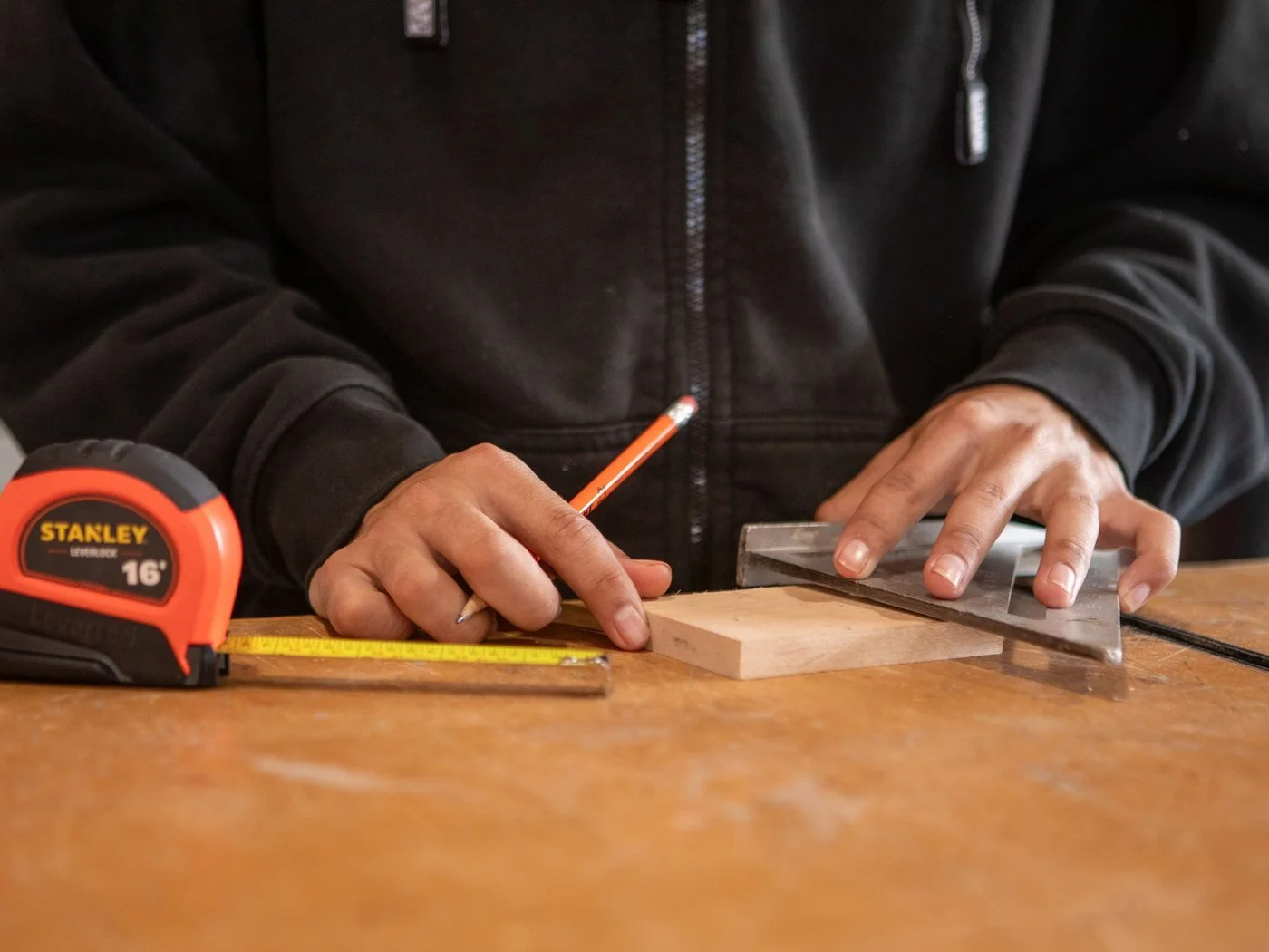 Carpenter measuring and marking wood for a precise repair