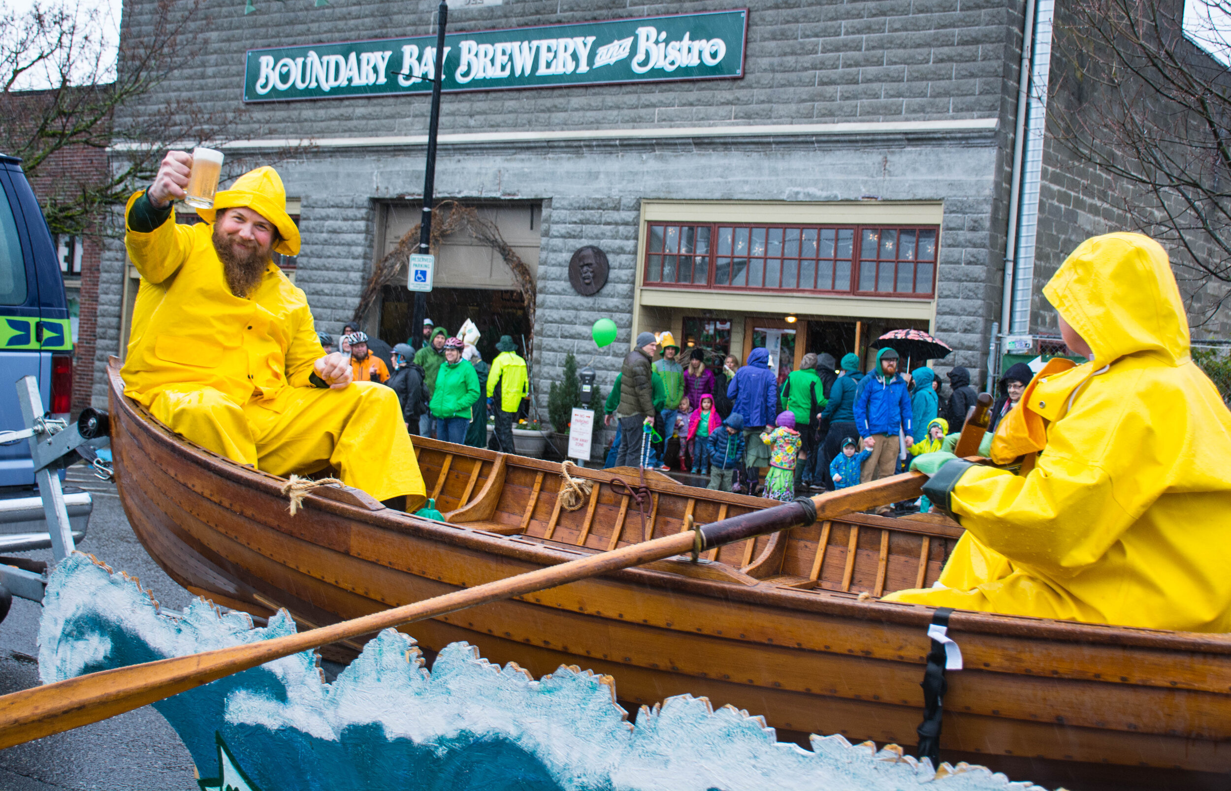 An image of Boundary Bay's "Boat Float" and its crew as it makes it's way to the end of the annual St. Patrick's Day parade. Boundary Bay Brewery can be seen in the backdrop.