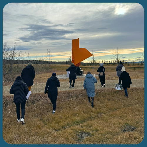 Workshop participants walk outdoors to share their artworks.