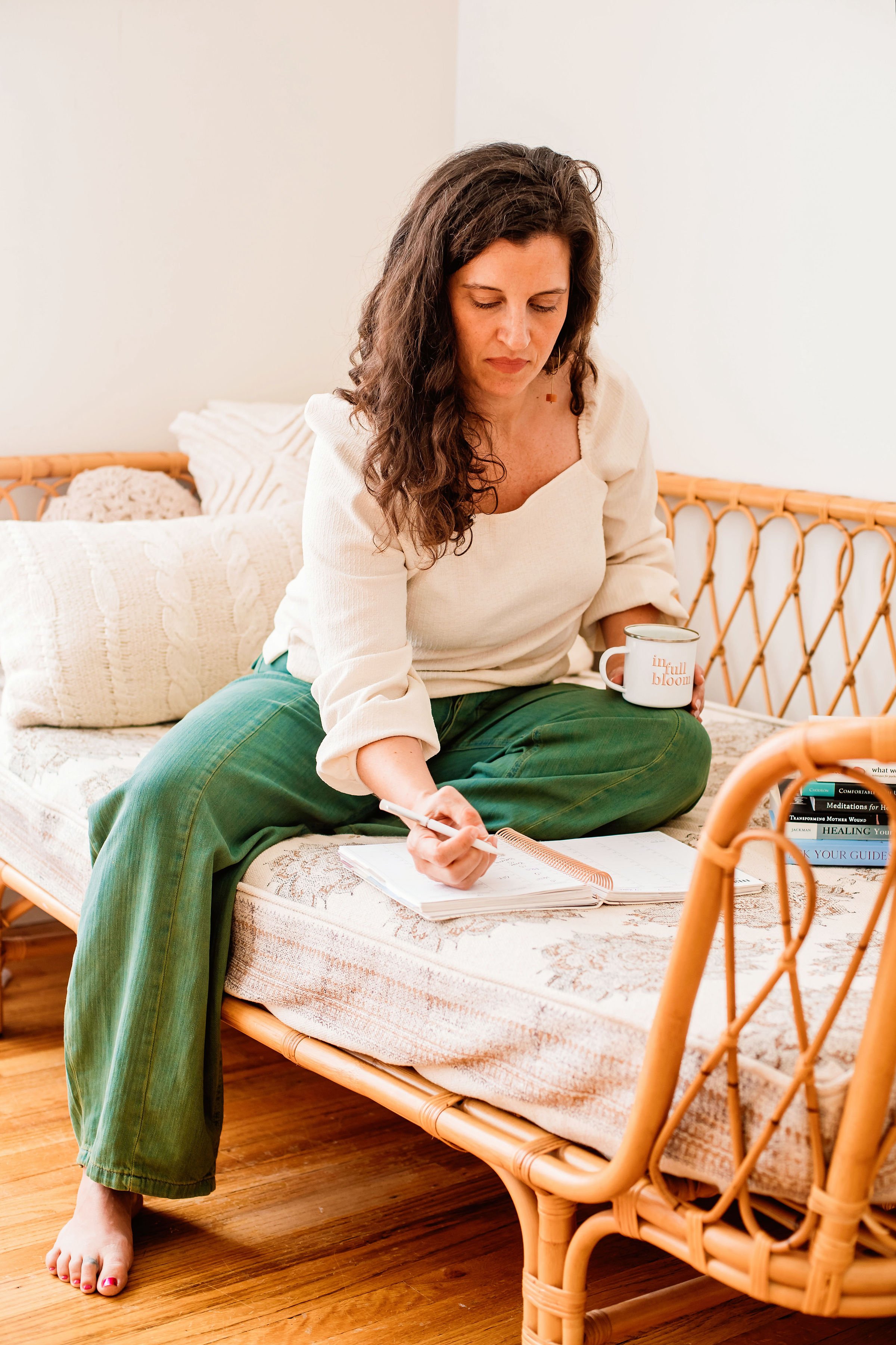 Photo of Brooke Stevenson sitting on a coach, writing in a journal