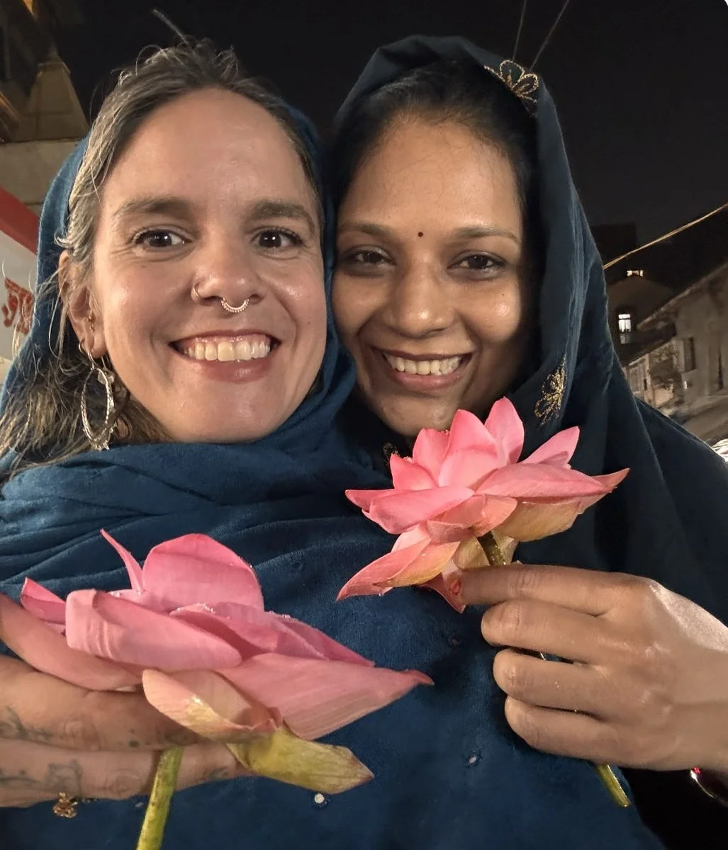 Adriana and Varsha holding pink lotus flowers