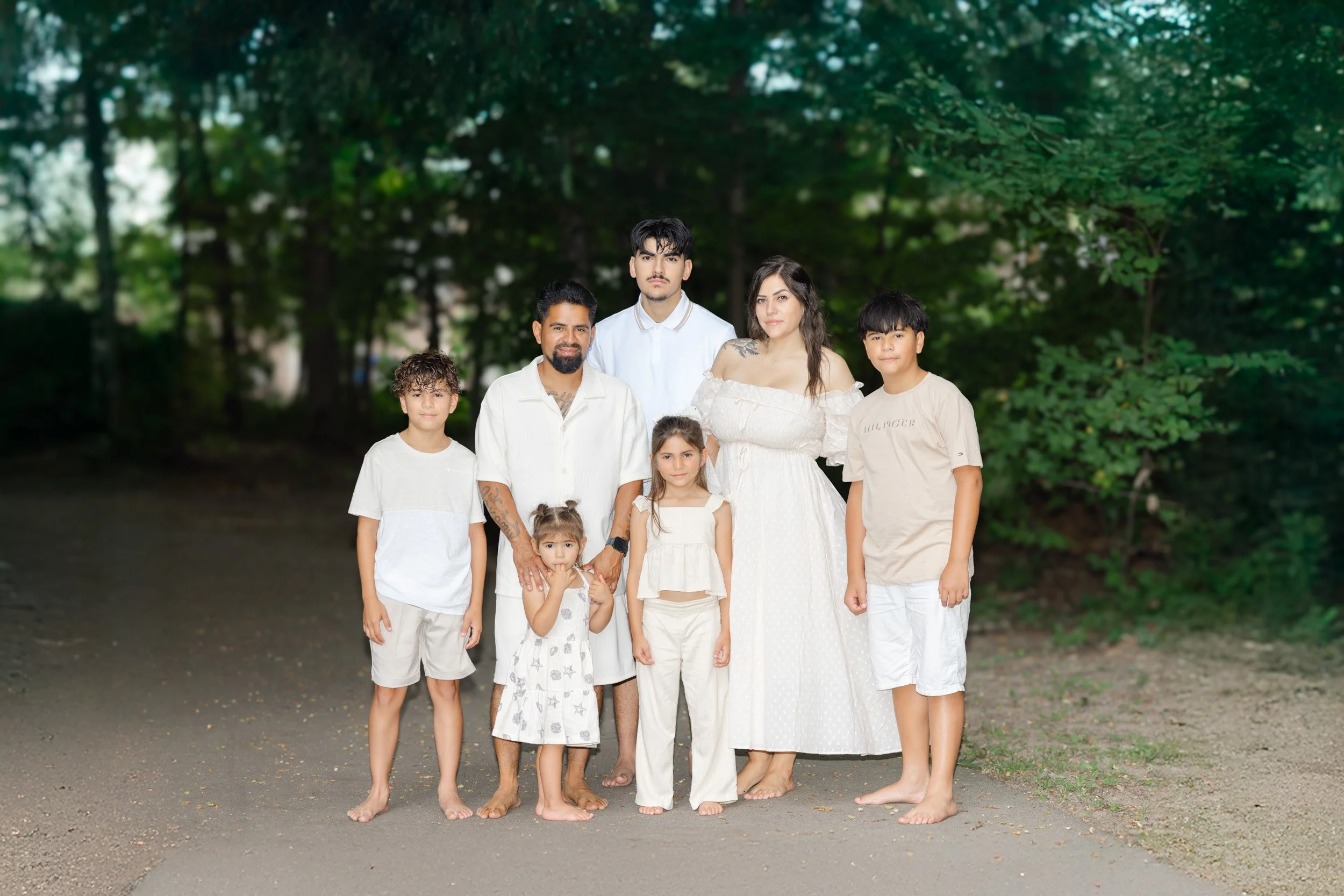 Family in chef attire playing with popcorn near stacked popcorn tins, with spilled popcorn on floor.