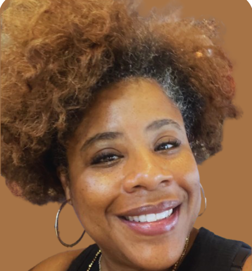 Close-up of a woman with curly hair, smiling, with hoop earrings, wearing a black top, against a brown background.