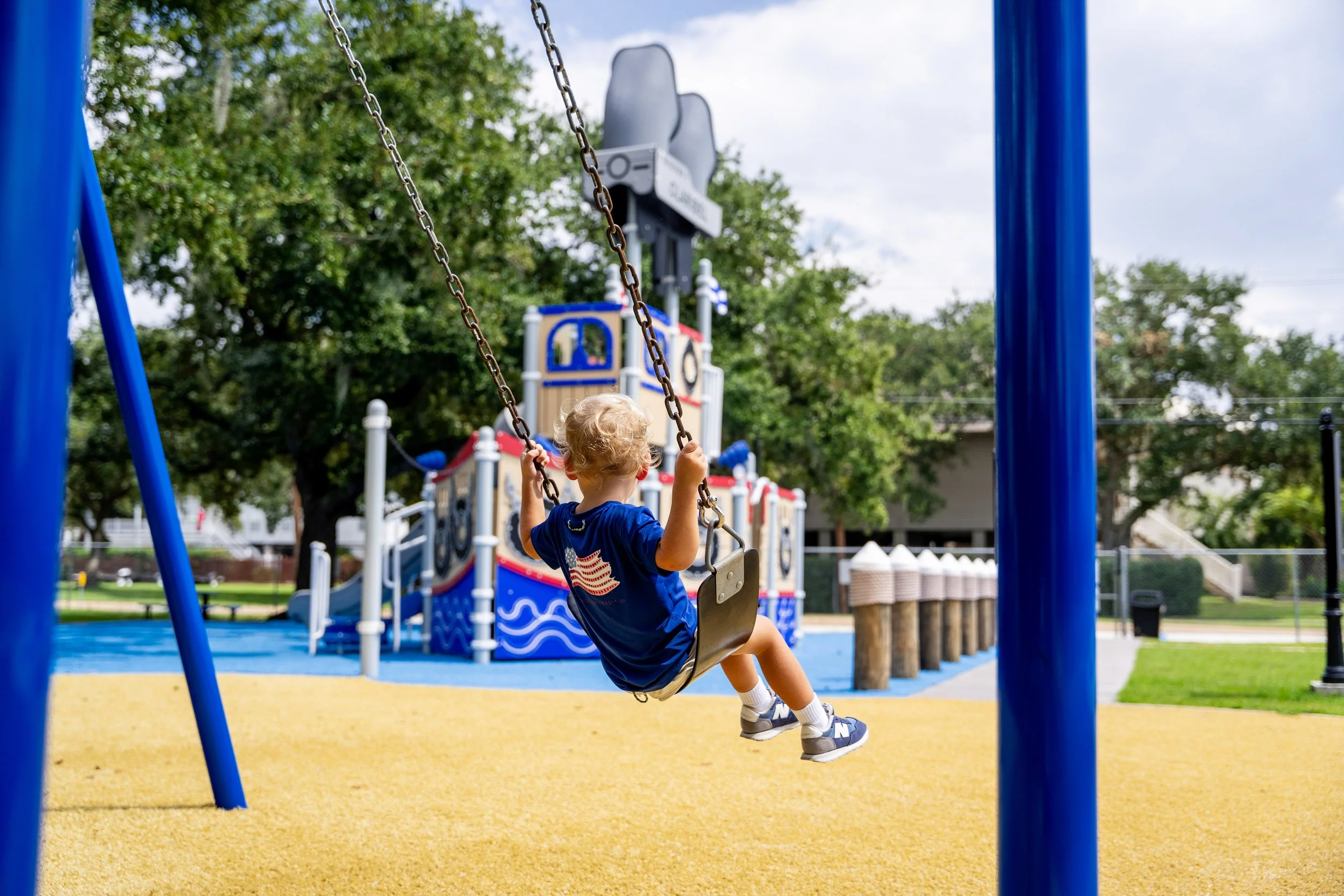51boy swinging on swing, commercial playground, playground photography, safety surfacing.jpg