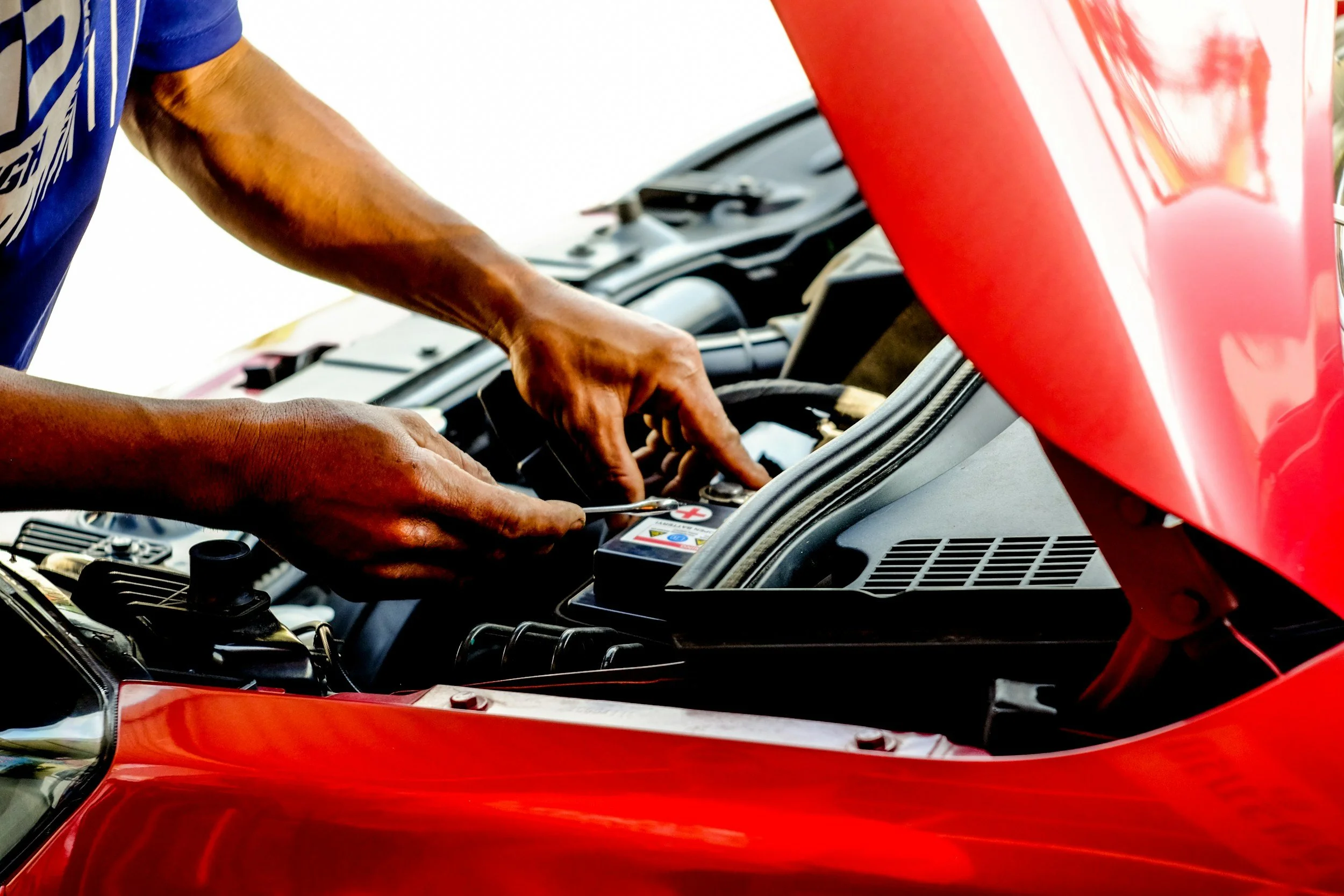 car repair technician hands under hood