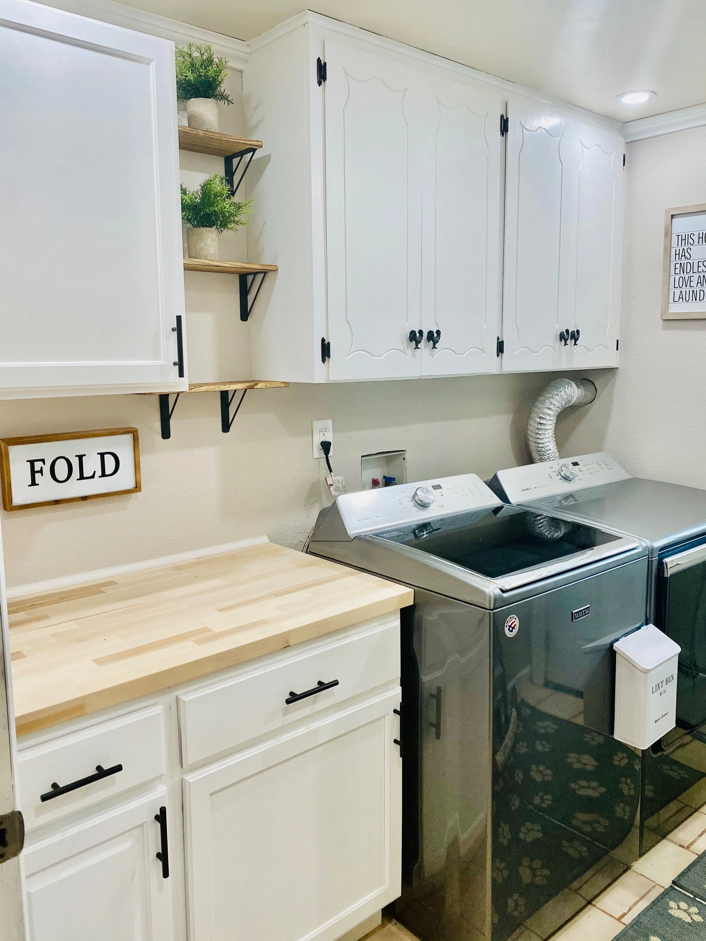 LAUNDRY ROOM AFTER  Painted cabinets, and a countertop for a folding table, new handles and all new crown and trim! We also added 5 can lights to brighten it up!