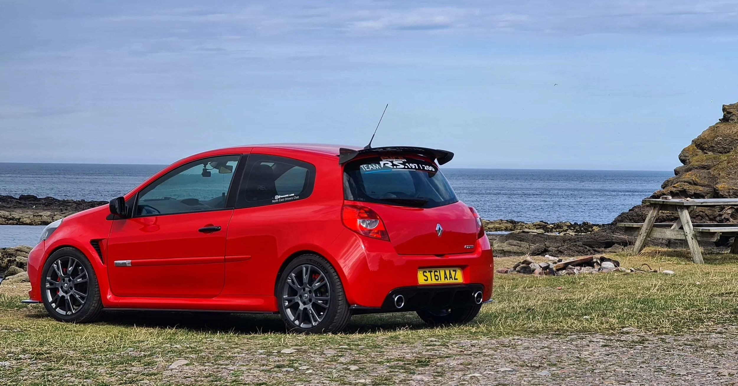 Modified red Renault Sport Clio 200 with the sea in the background.jpg