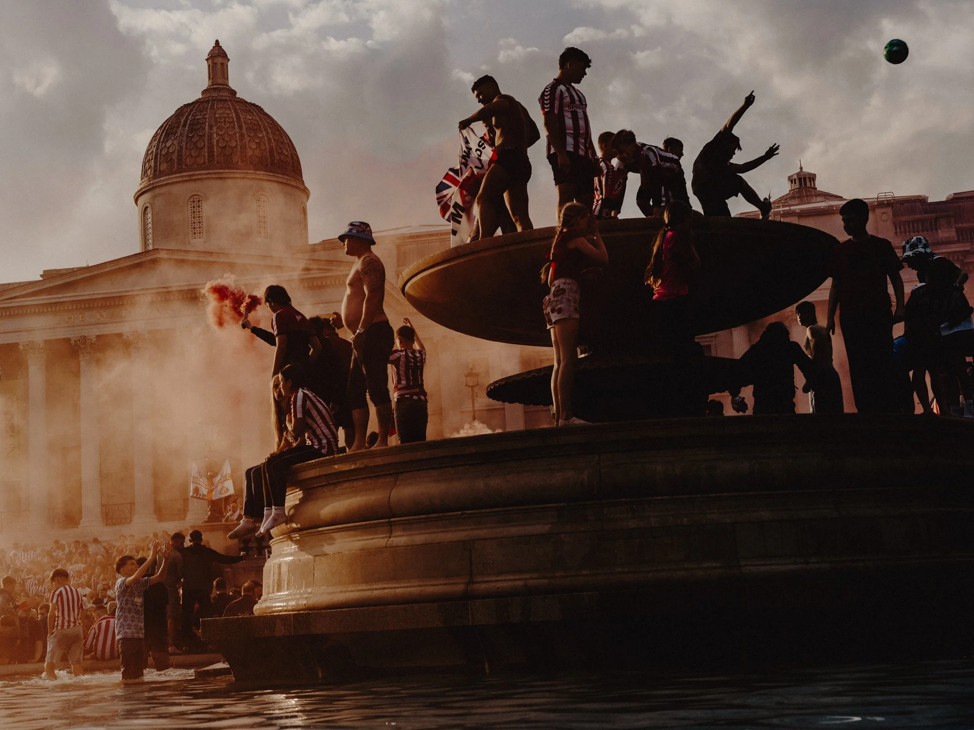 Cinematic street photography moment in smoke filled Trafalgar Square London by Joshua K Jackson.