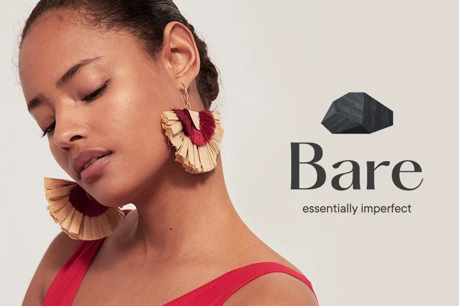 Mujer con aretes grandes de rafia y cartelería de la marca Bare con lema "essentially imperfect".