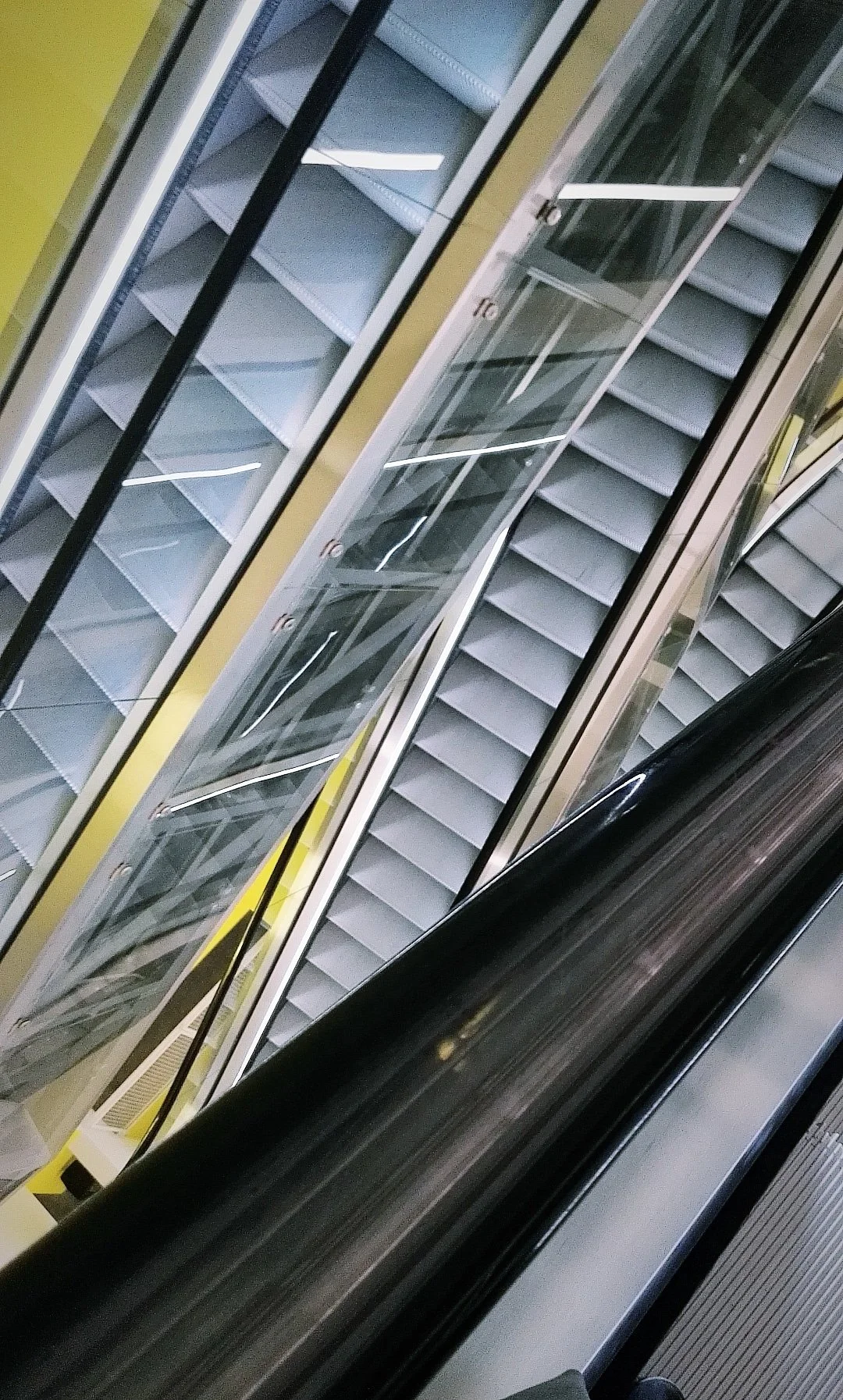 Escaleras mecánicas en un centro comercial o edificio, vistas desde arriba.