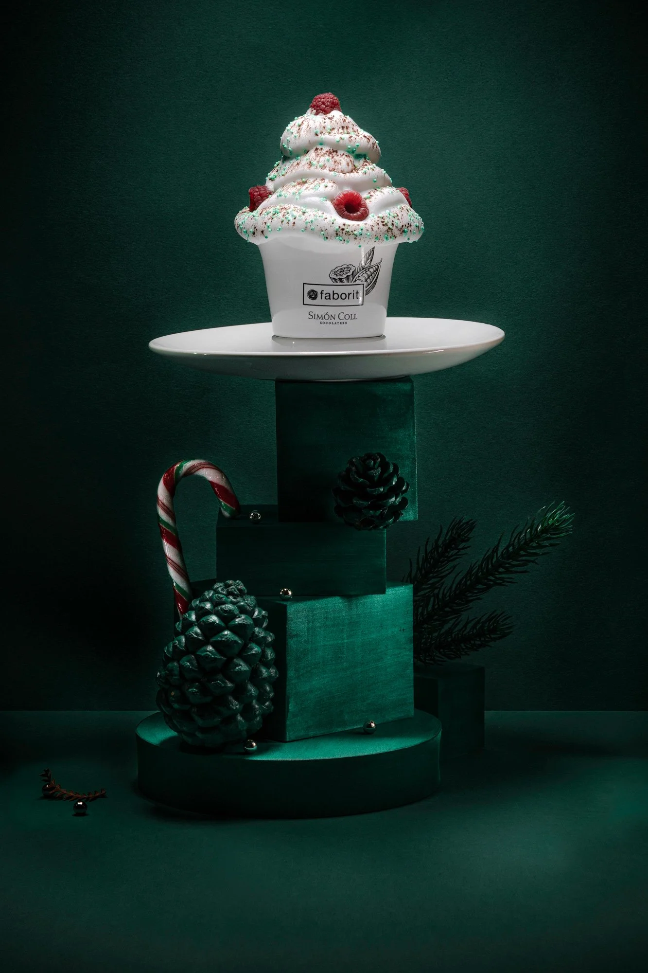 Postre navideño que parece helado decorado con fresas, frambuesas, espolvoreado con azúcar y confeti de colores, en un envase blanco con el logo 'Faborit' y 'Simón Coll'.