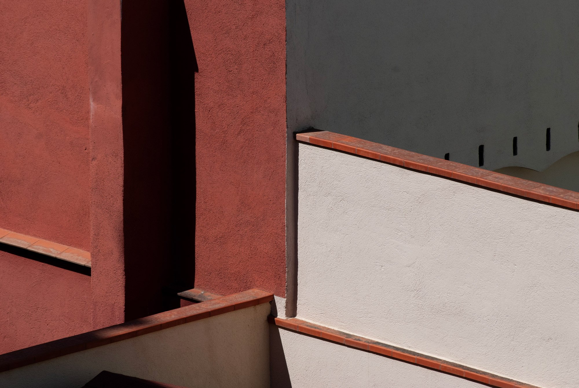 Áreas de paredes en diferentes colores, con sombras y detalles de bordes de paredes y techos en un edificio.