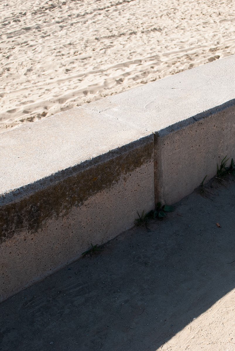 Muro de concreto junto a la arena de una playa. Fotografía digital de Barcelona. Fotografía urbana de Barcelona por Agosto Creative Studio.