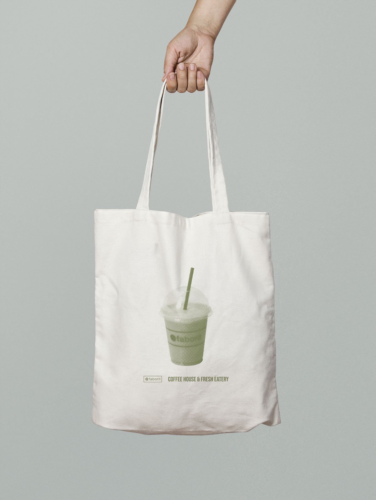 Bolsa de tela sostenida por una mano, con imagen de un vaso de bebida con popote y texto "Coffee House & Fresh Eatery".