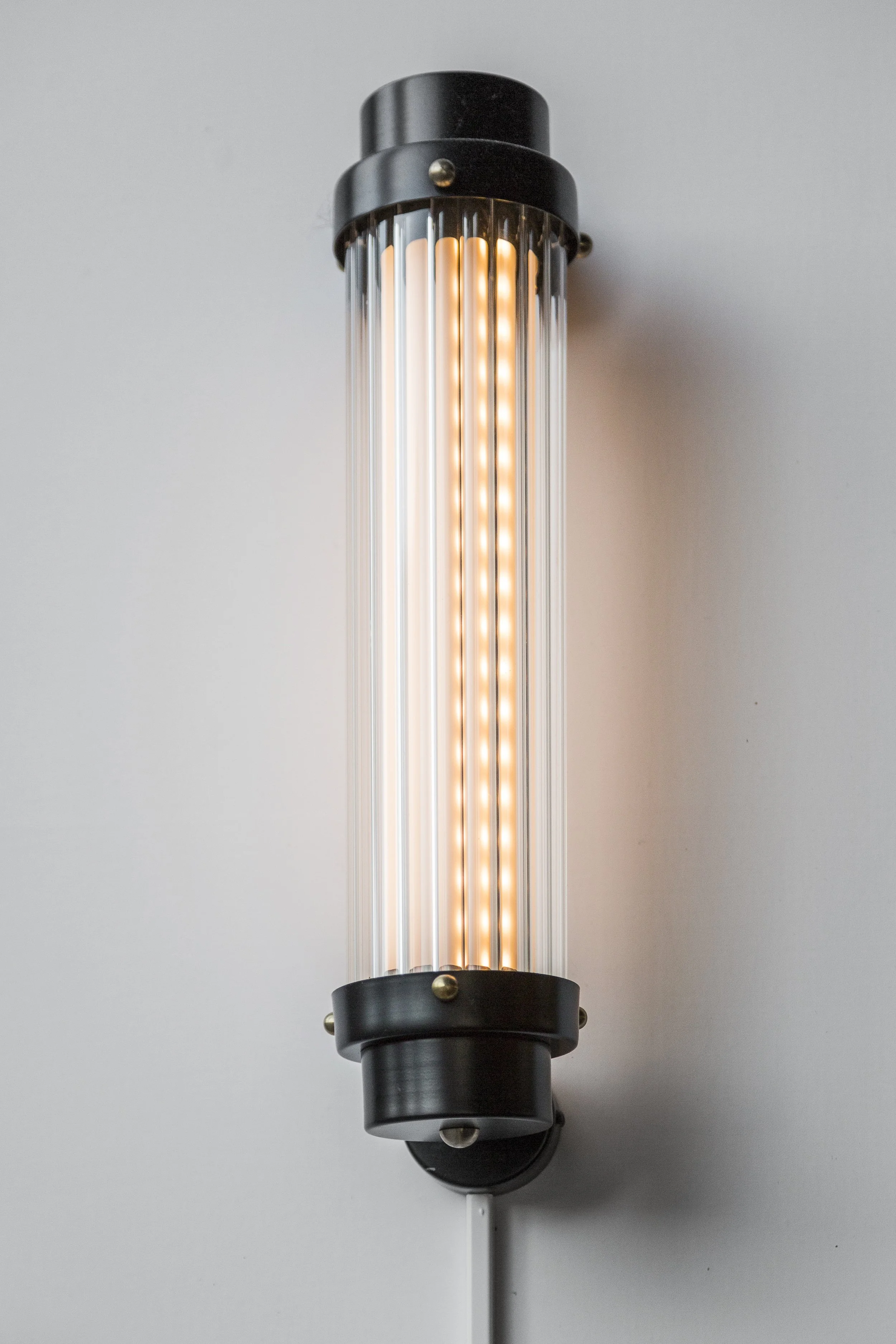 Lámpara de pared cilíndrica de estilo industrial con luces LED. Diseño de interiorismo comercial. Retail Design.