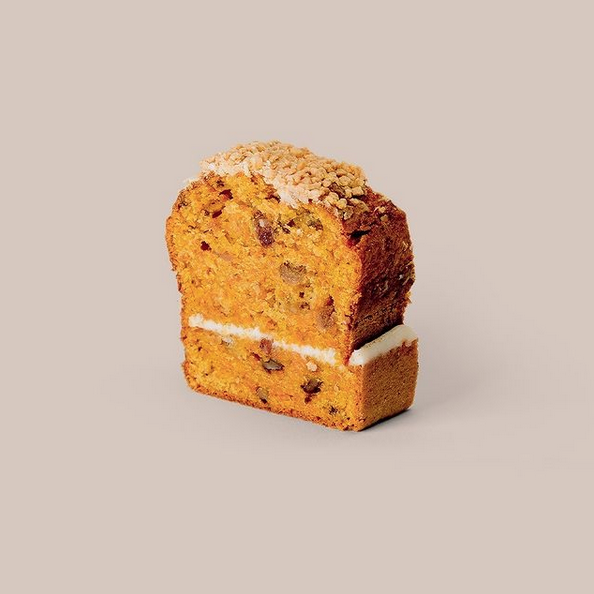 Porción de pastel de calabaza con relleno de crema y cobertura de crumble.