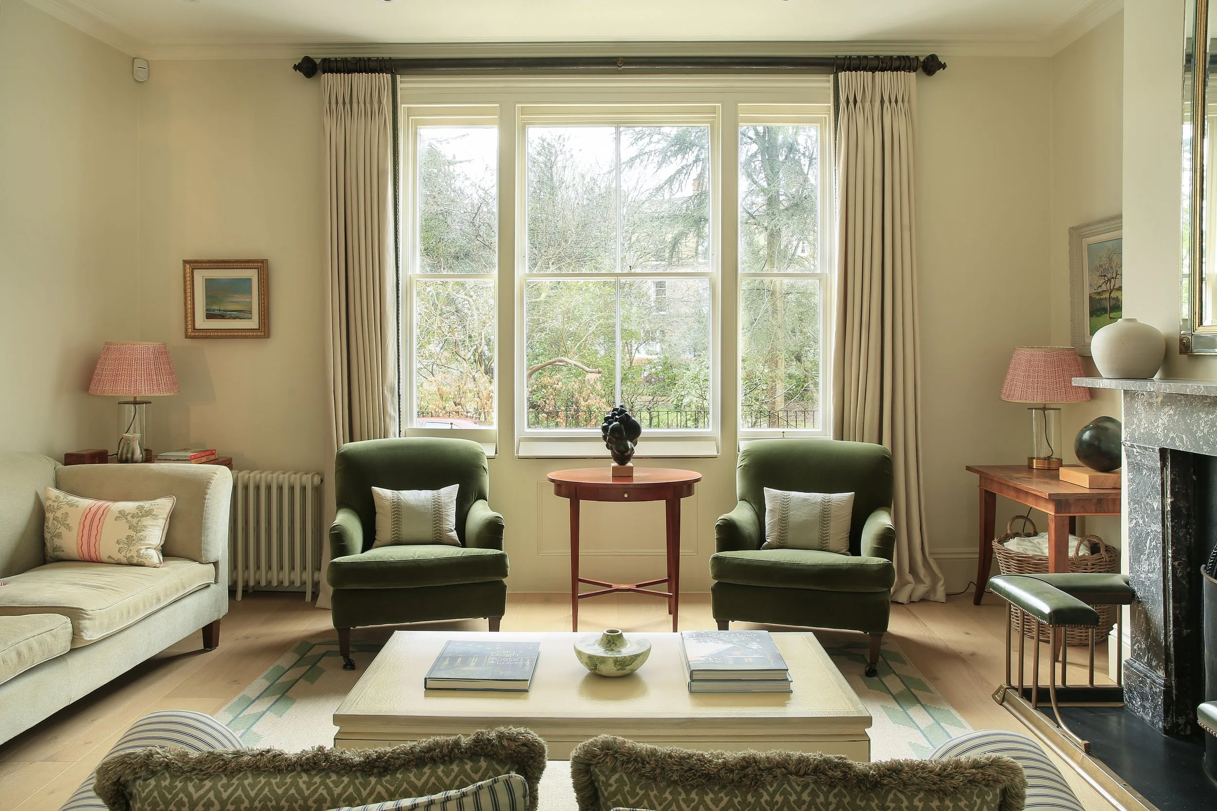 Oxford townhouse sitting room looking out at two green armchairs and soft cream interiors