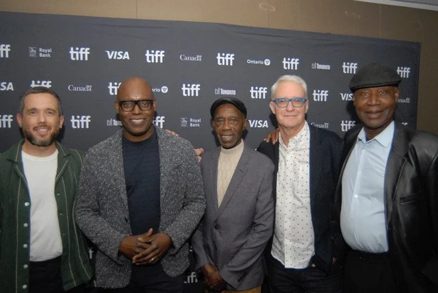 Five men standing together at a TIFF event, posing for a photo in front of a black backdrop with TIFF and sponsor logos.