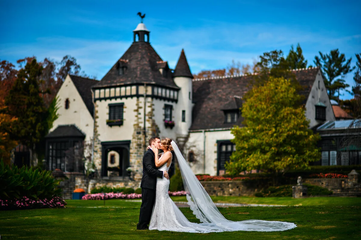 Bride and groom kiss in front of Chateau Castle