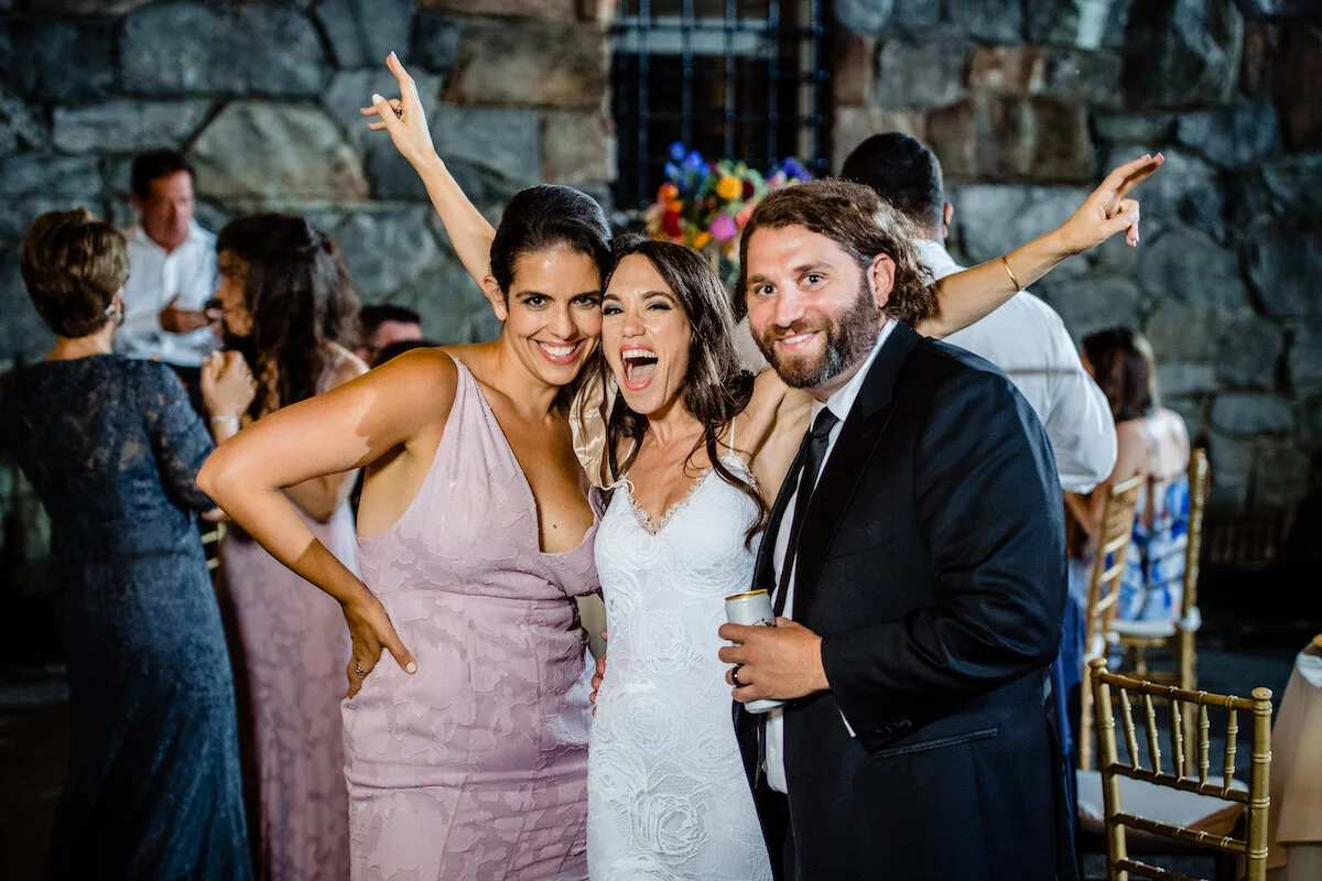 Bride, maid of honor and groom pose together