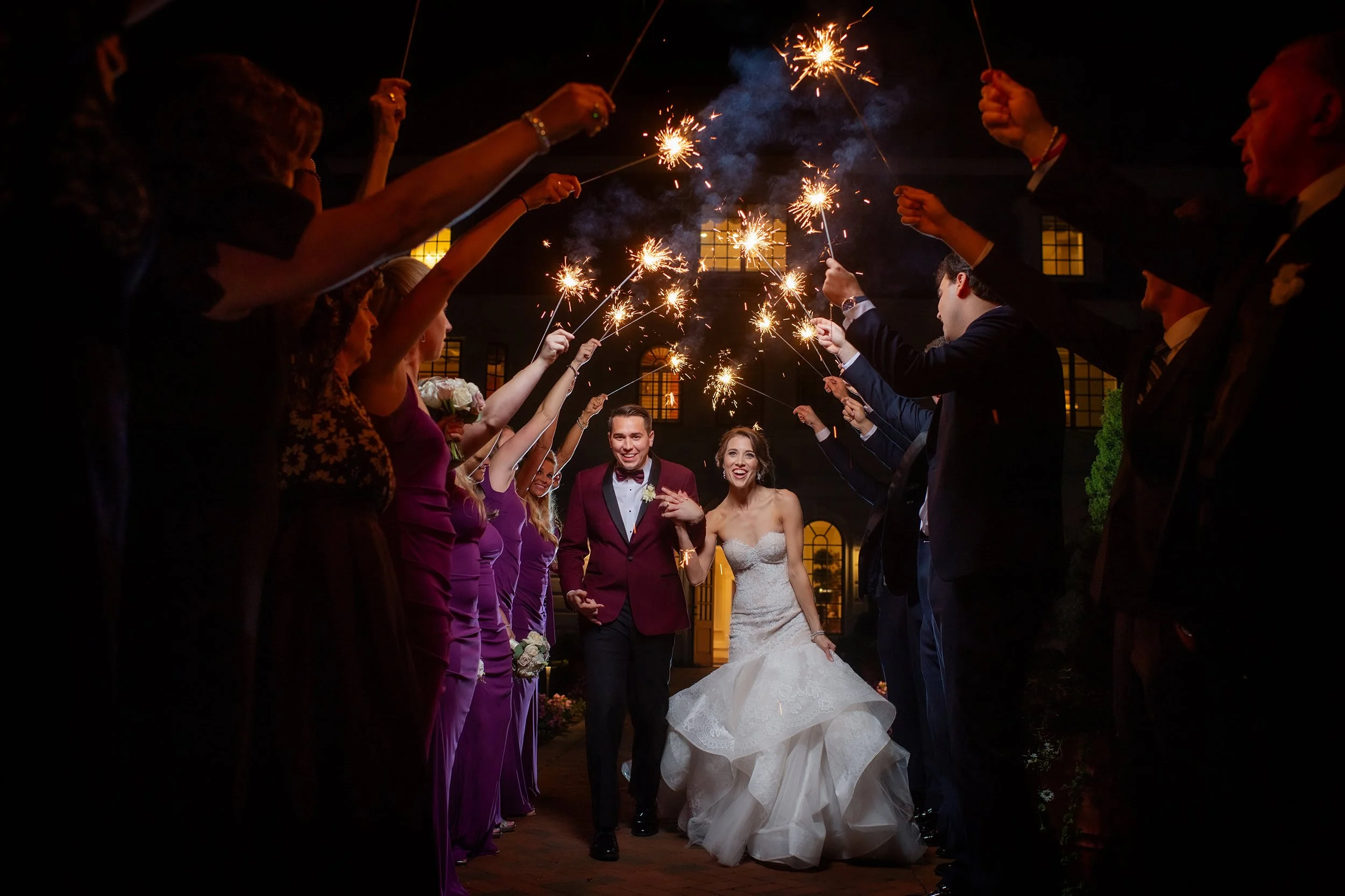 happy couples exits wedding wedding party sparklers in the air