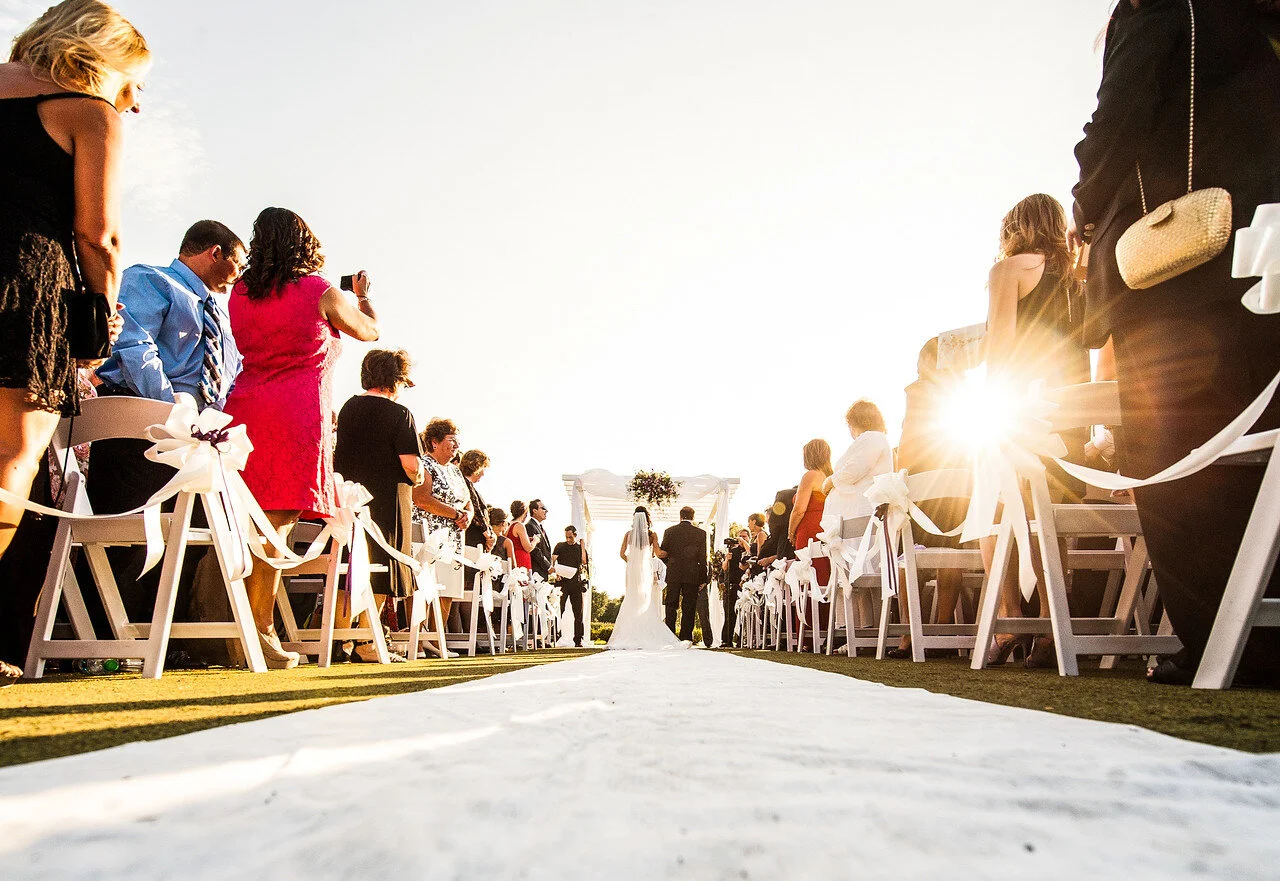 Look down the aisle at bride and groom outdoor wedding