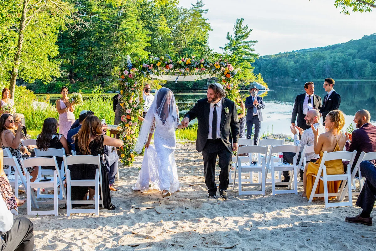 Bride and groom walk down the aisle as newly married husband and wife