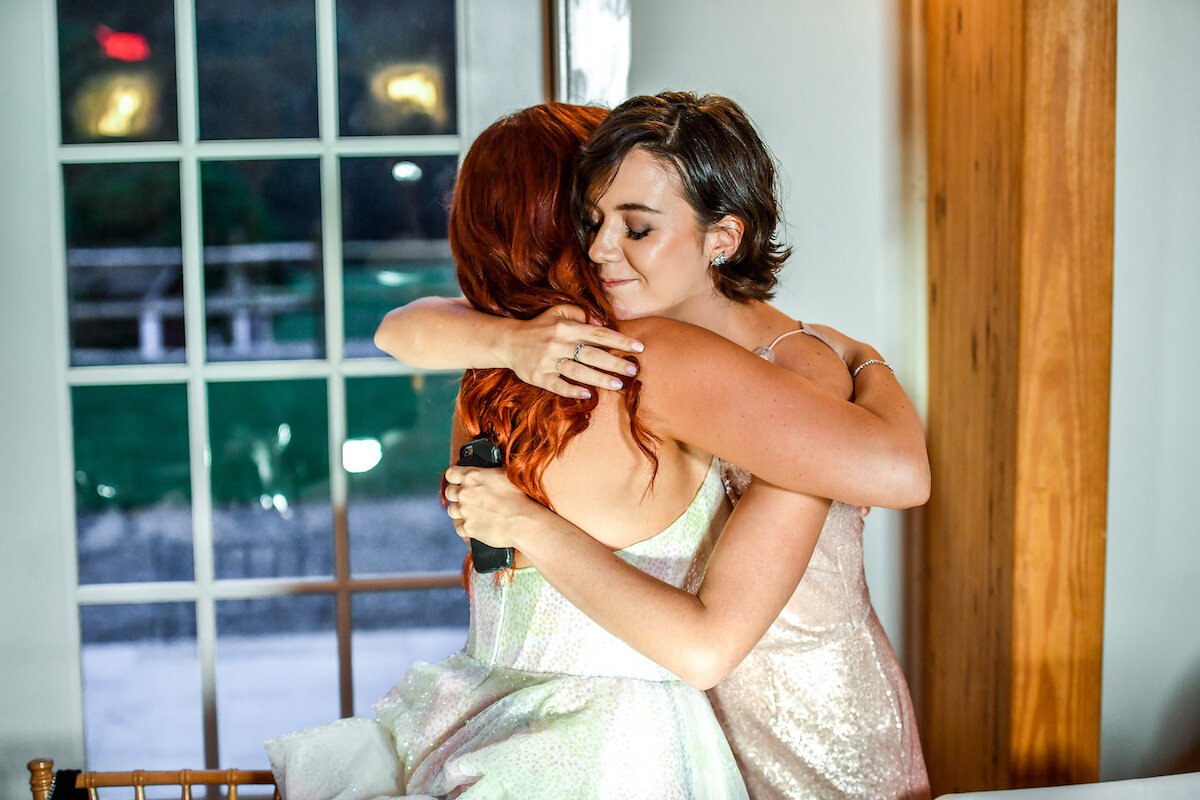 Maid of honor and bride embrace after speech