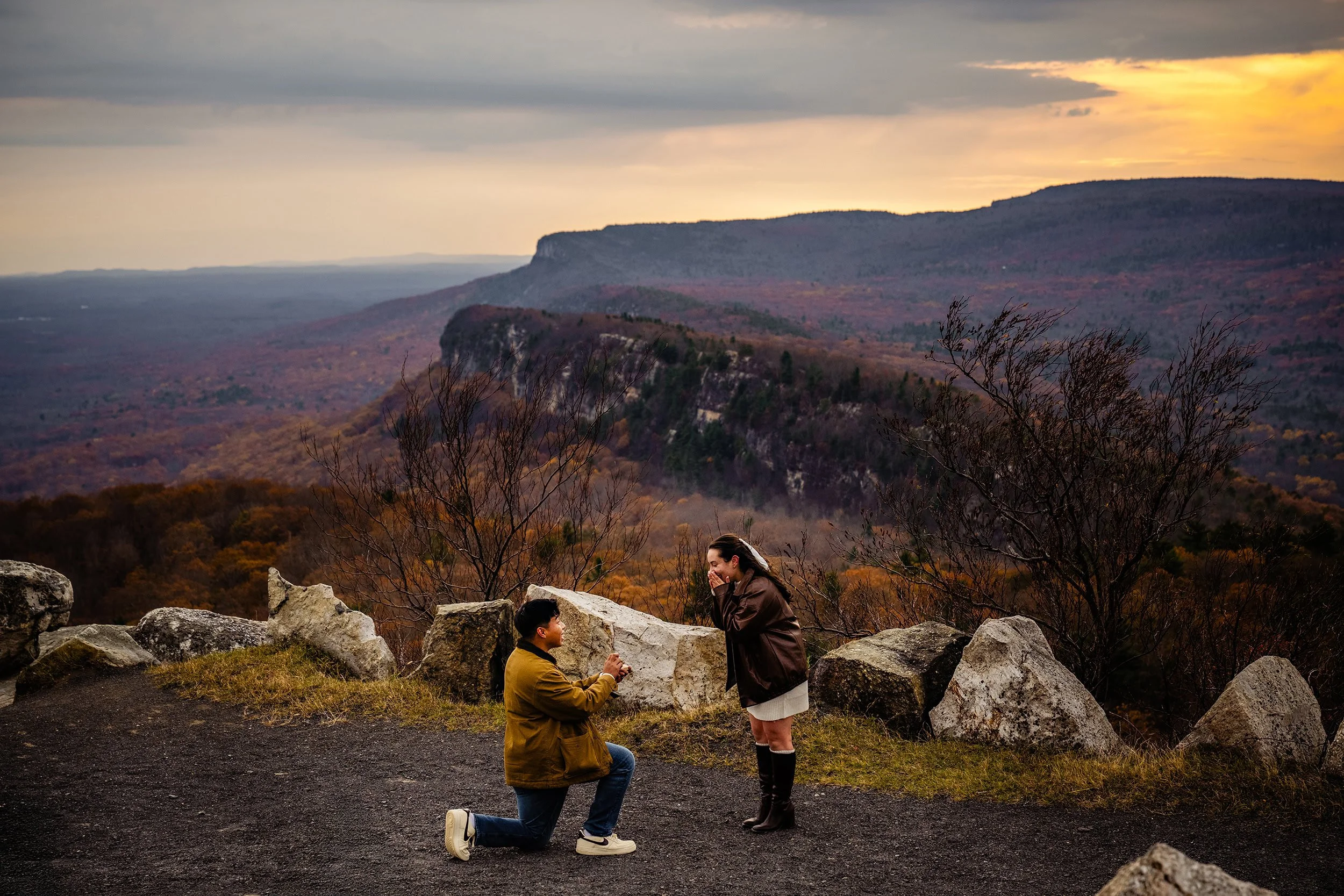 Photography by Jeff Tisman. On one knee proposing to his girlfriend the scenic views of the  Hudson Valley fan out all around them.