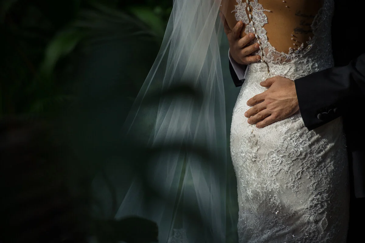 Grooms hands on bride's waist