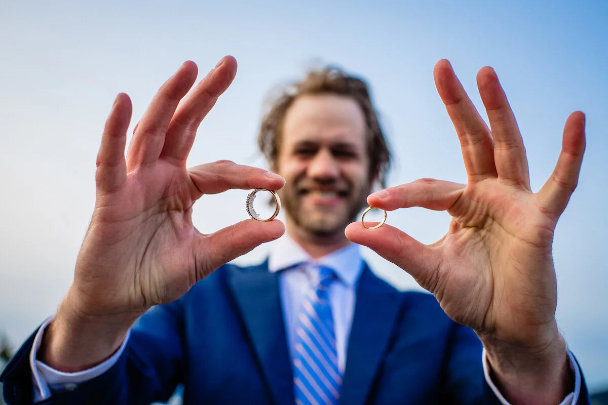 Groom holding wedding rings
