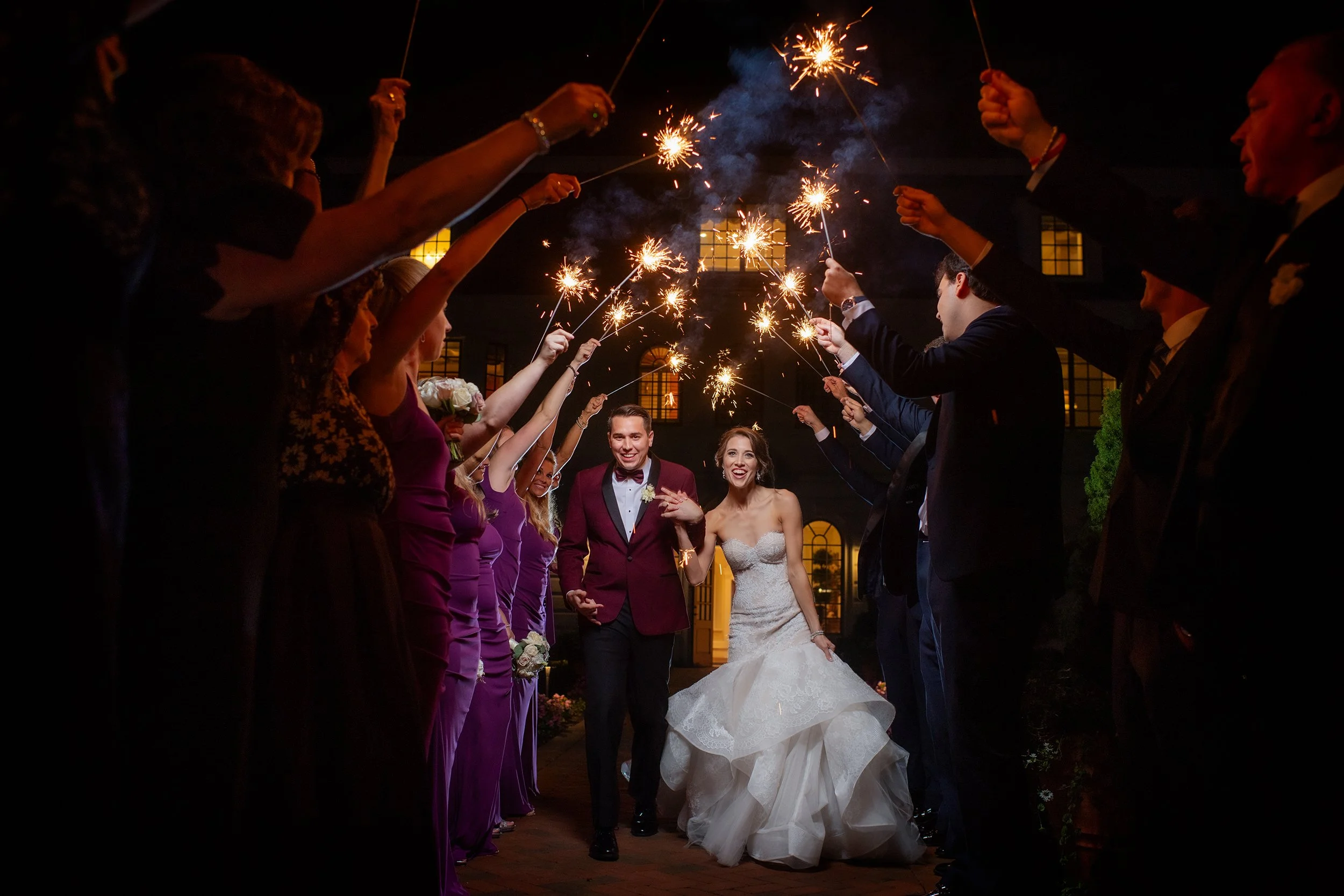 Bride and groom say their final goodbyes and guests line with sparklers