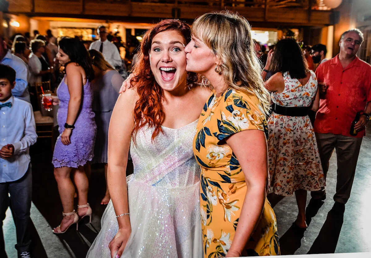 Guest kisses brides cheek on dance floor