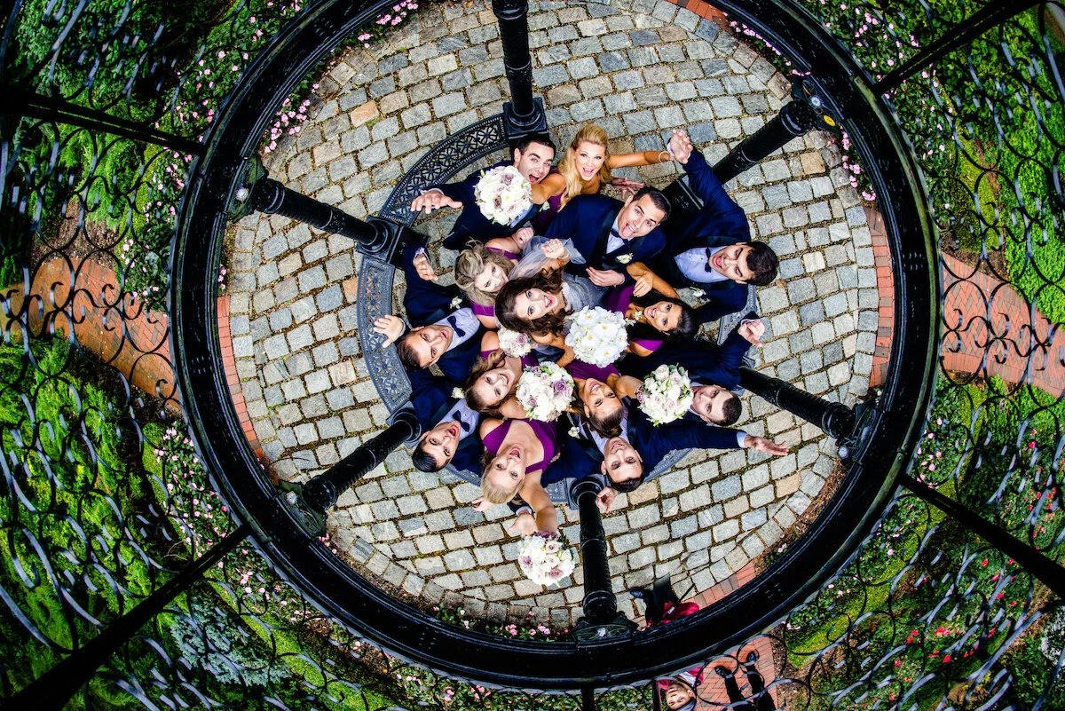 Drone view of bridesmaids and groomsmen smiling at camera