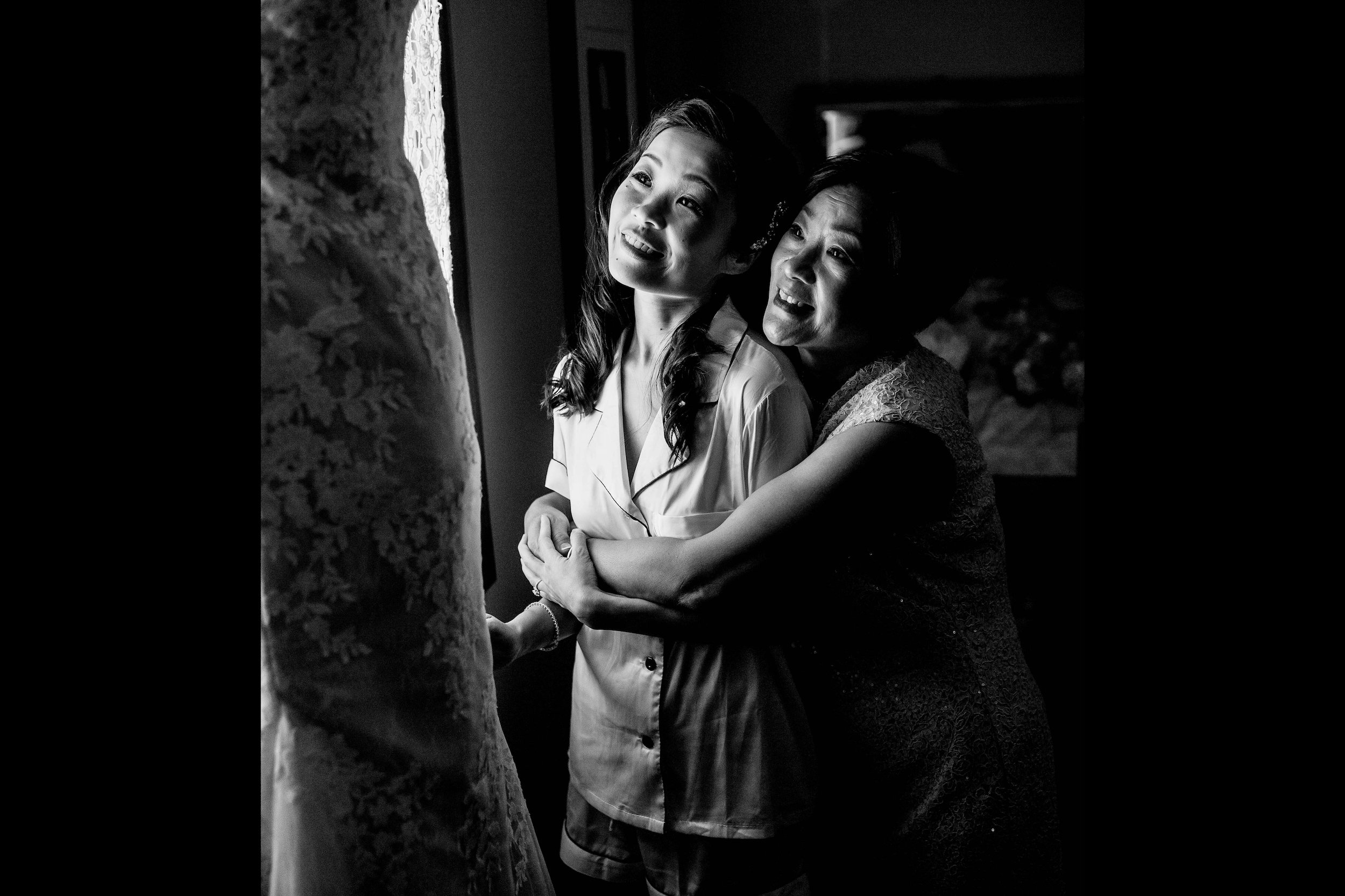 Bride and mother of bride look at wedding dress