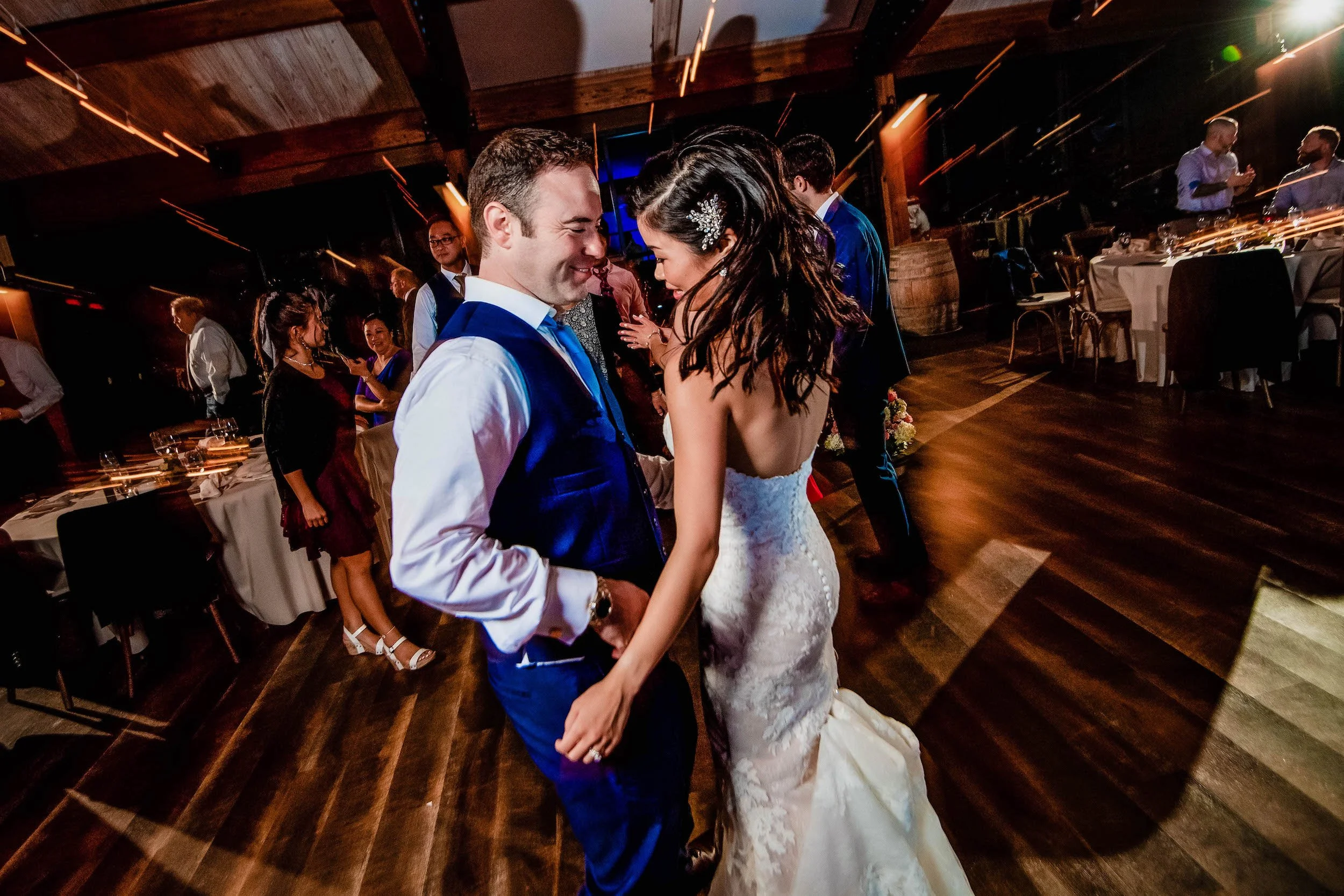 Bride and groom dance with guests out of focus