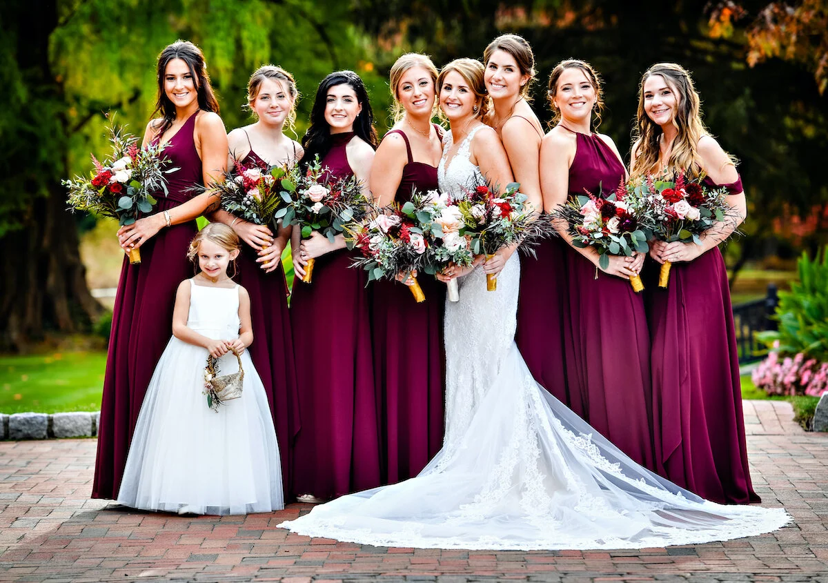 Bride and bridesmaids pose on cobblestone road