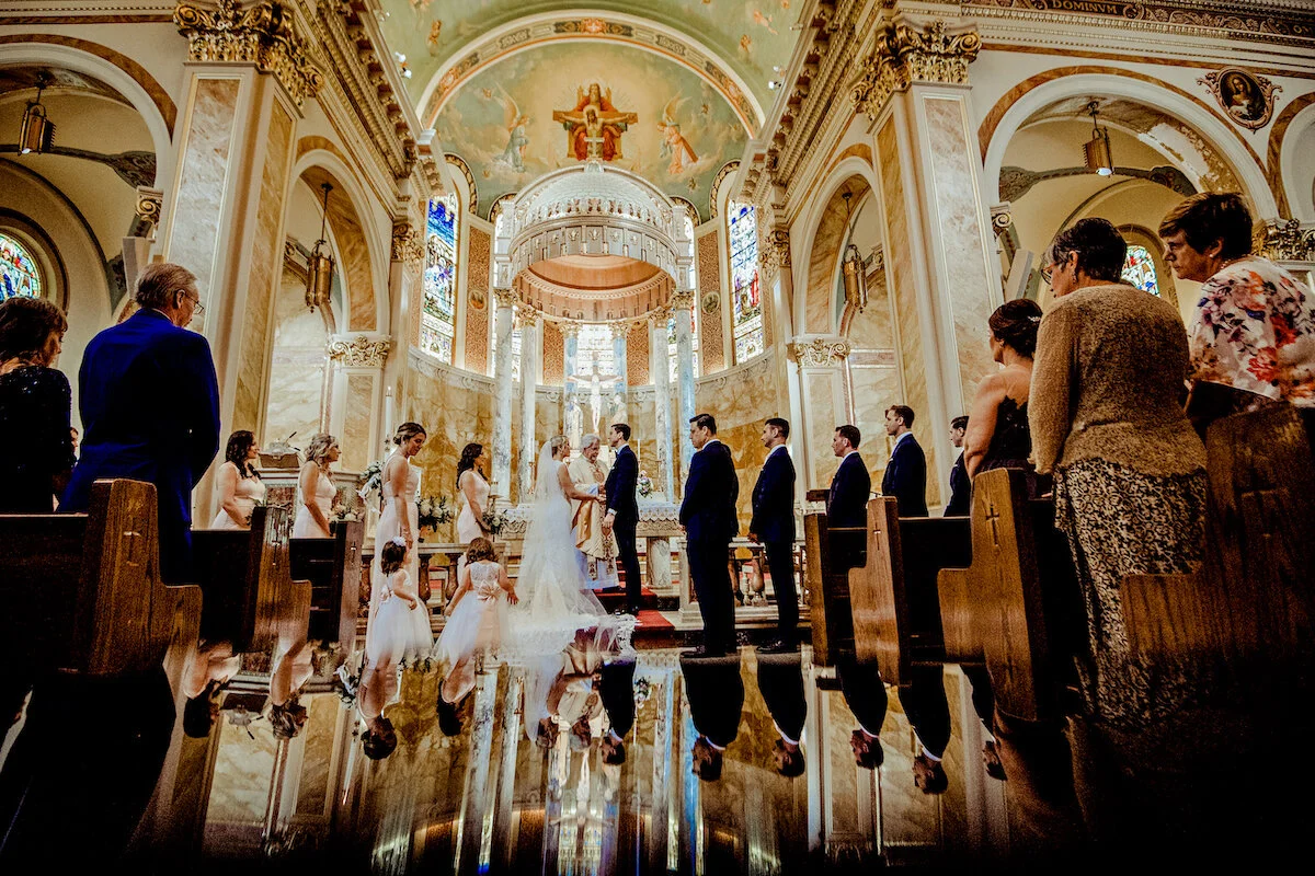 Bride and groom with bridal party at church alter