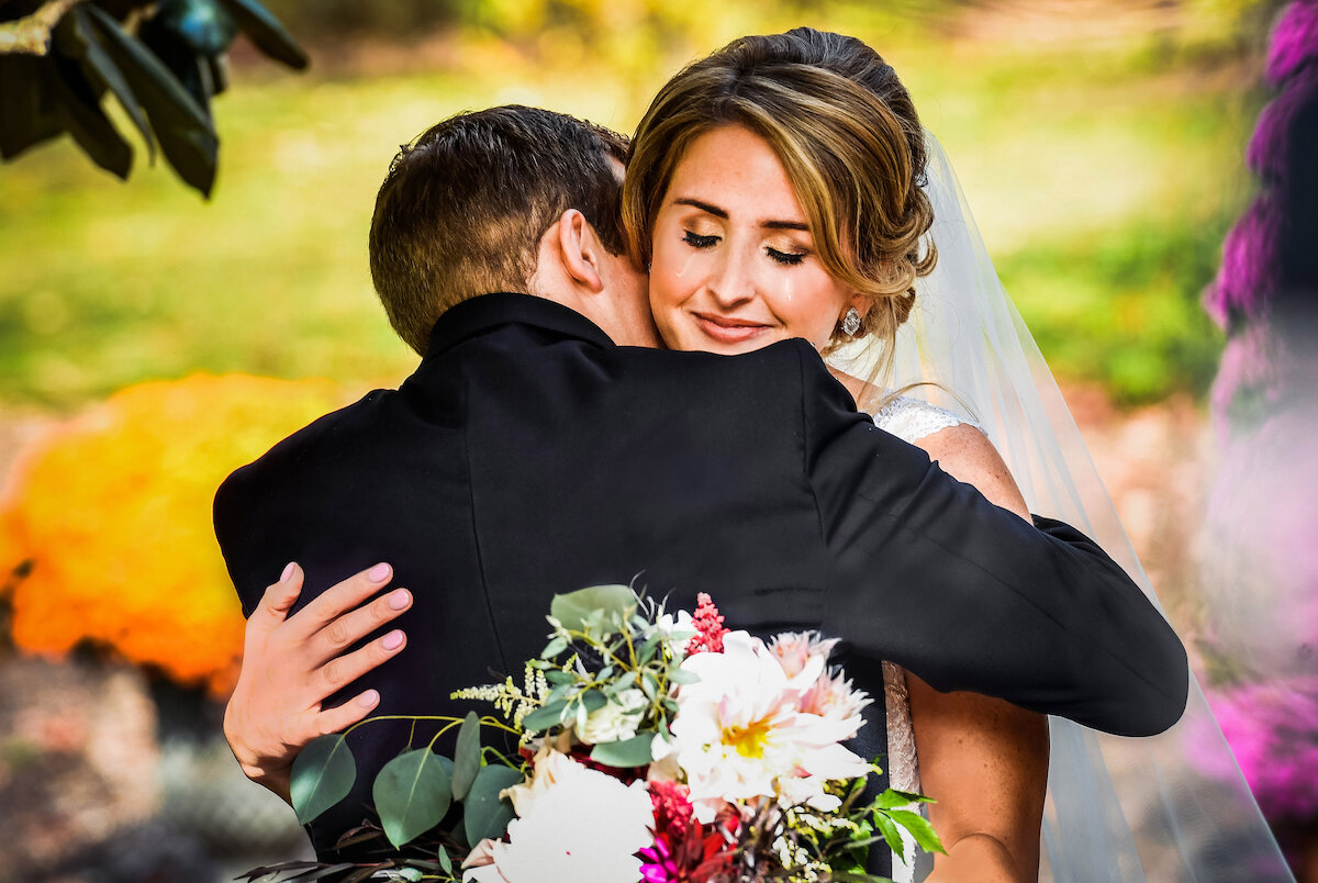Bride embraces groom with tears in her eyes