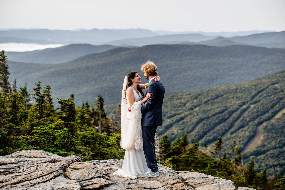 Bride and groom embrace on Vermont mountain top