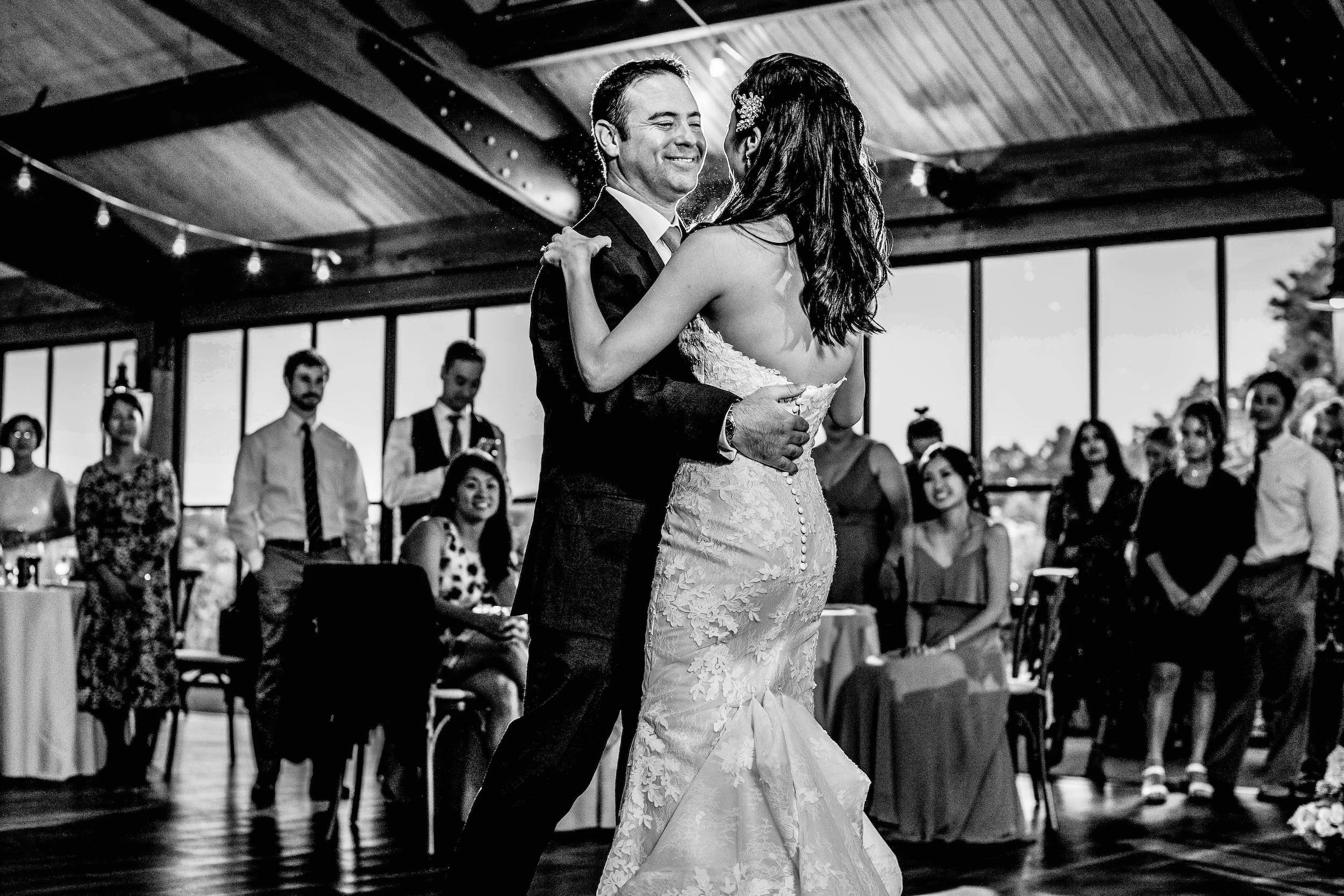 Bride and groom share first dance as guests watch